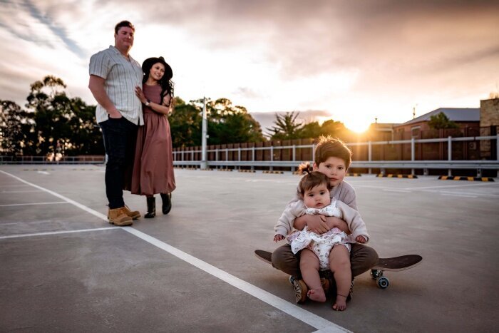 Family of four on urban rooftop carpark at dusk by Melbourne Family Photographer Kate Cashin
