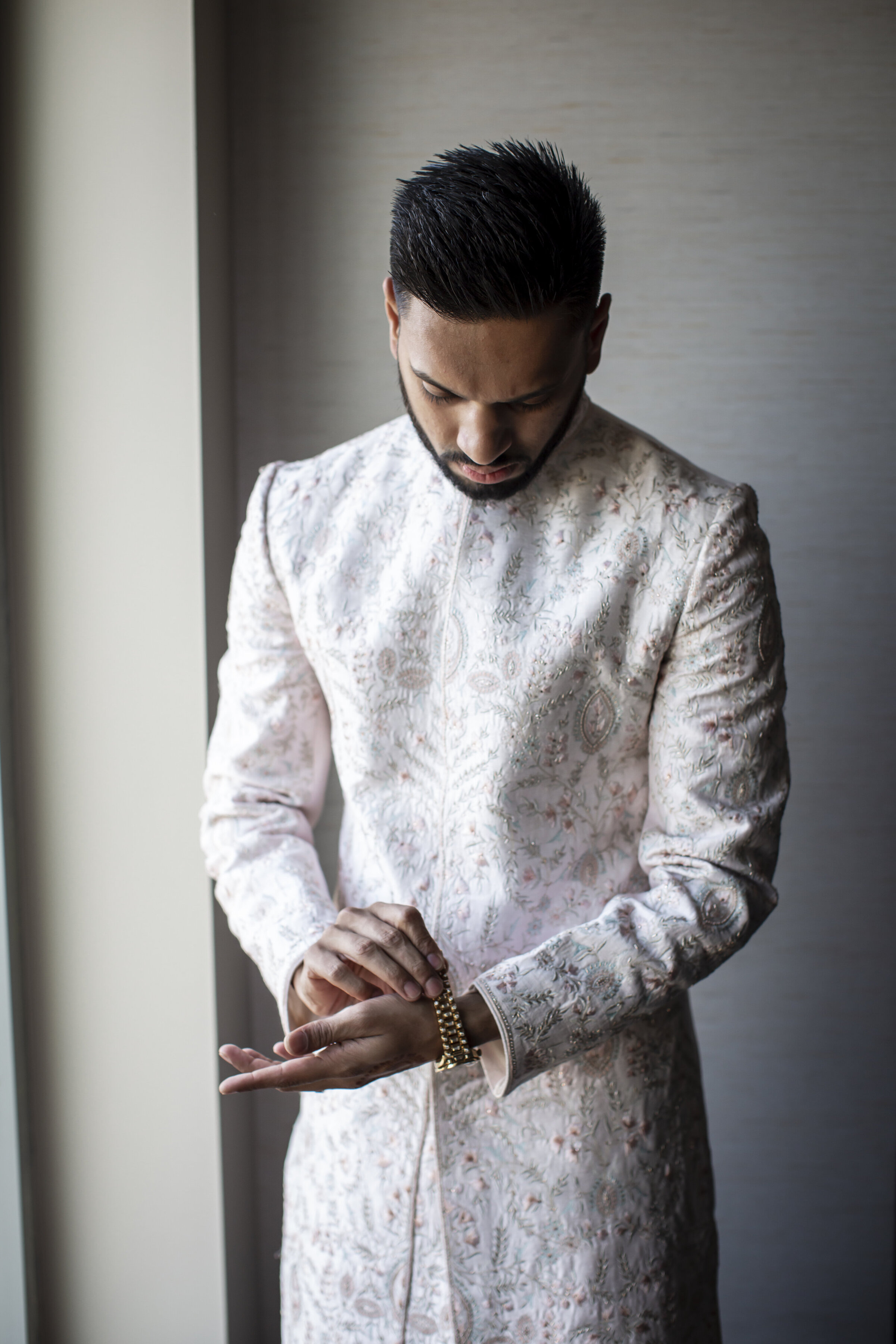 Indian groom putting on watch.