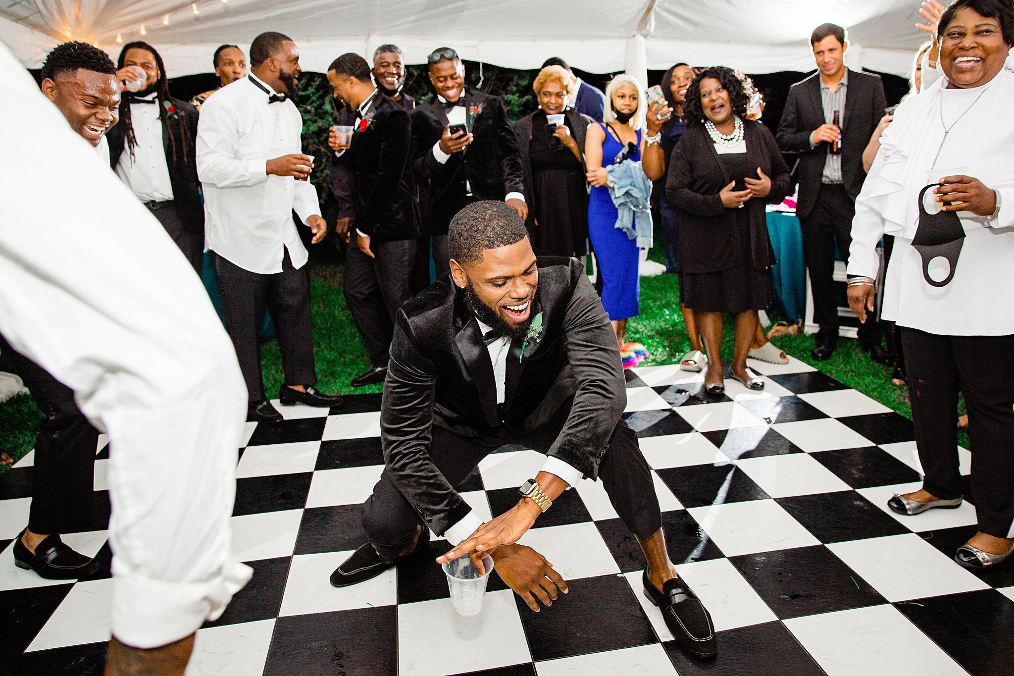 Groomsman dancing on black and white checkerboard dance floor