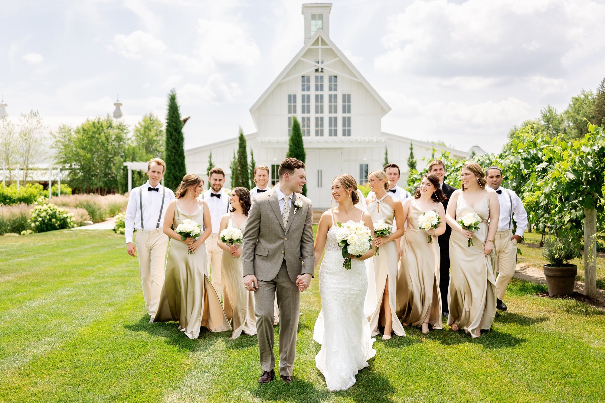 bridal party smiling and walking in front of church, taken by minneapolis wedding photographers by Kacey Wyrick Photography