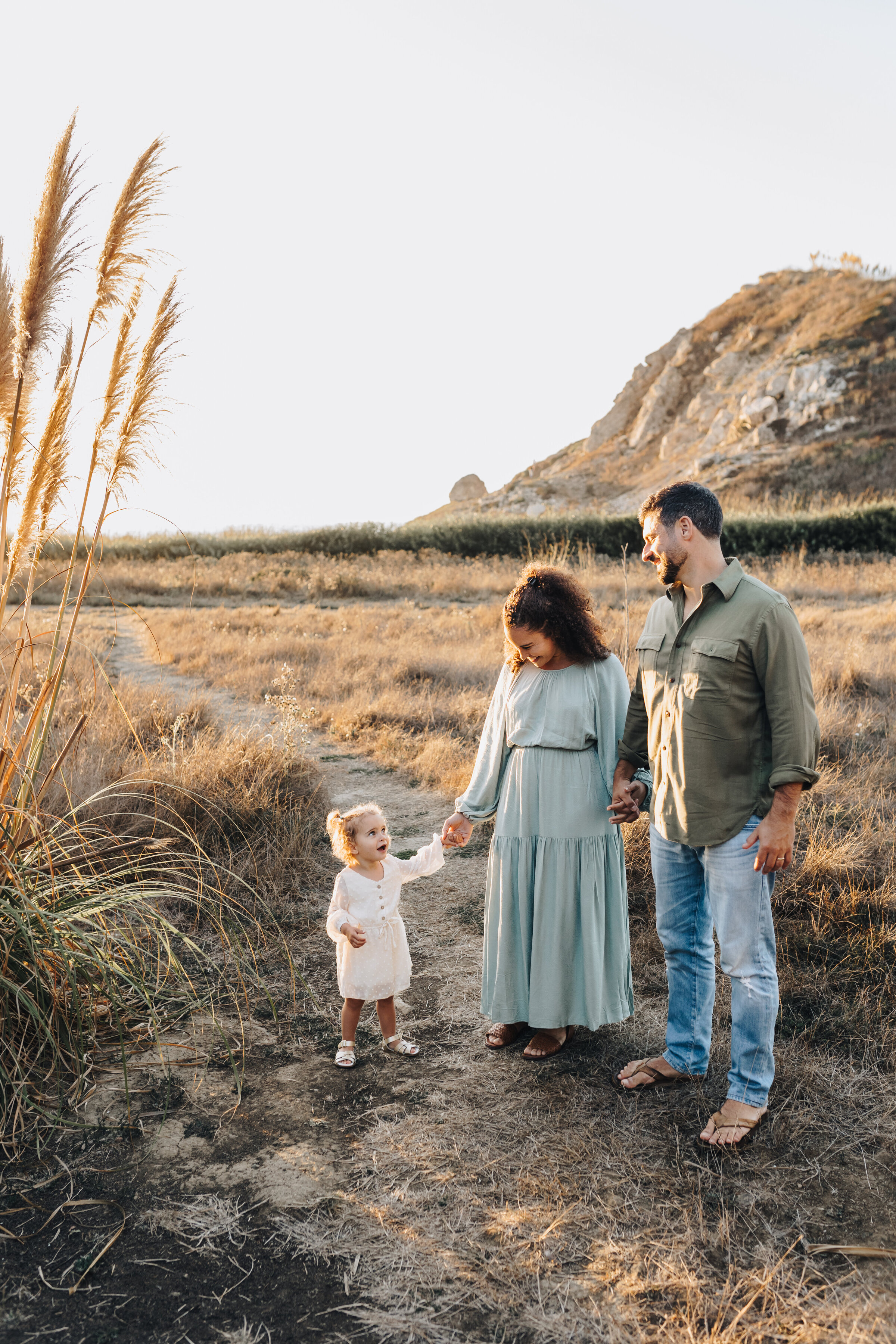 Family walks together amidst the pampas grass