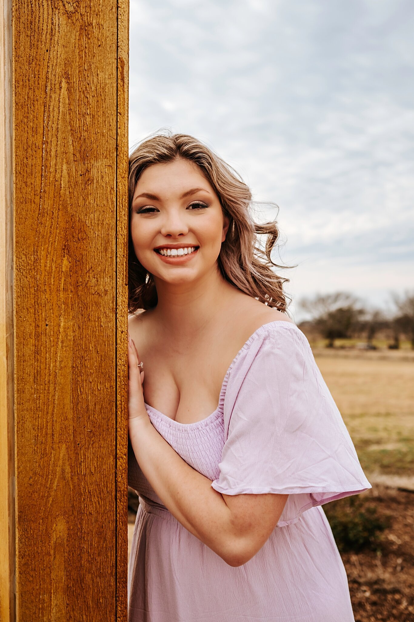 Seattle Senior girl learning on a greenhouse for her senior photoshoot wearing a purple dress from Shop Morning Lavender