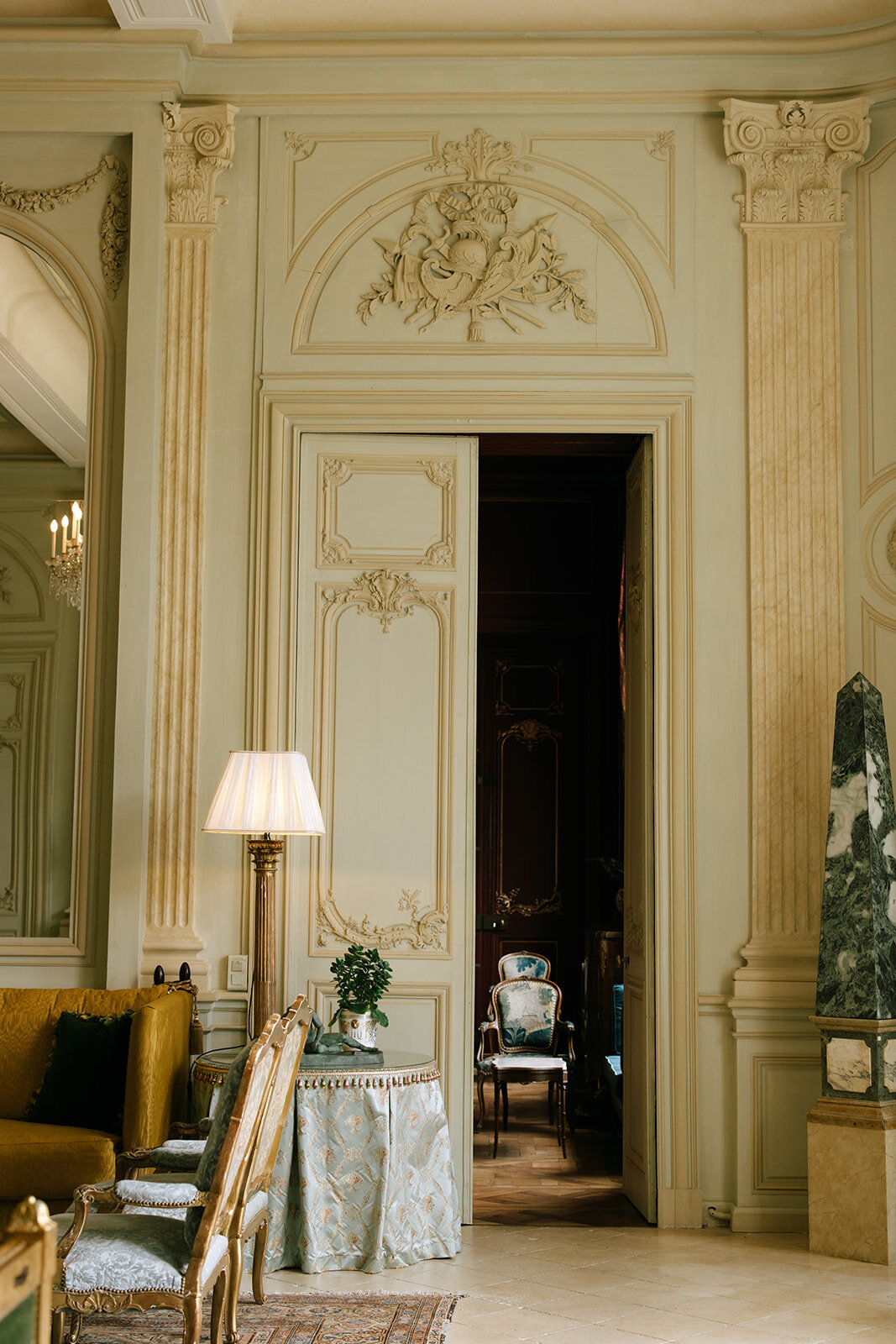 An elegant French chateau interior showcasing an ornate doorway, classic furnishings, and luxurious architectural details for La Perle Retreats.