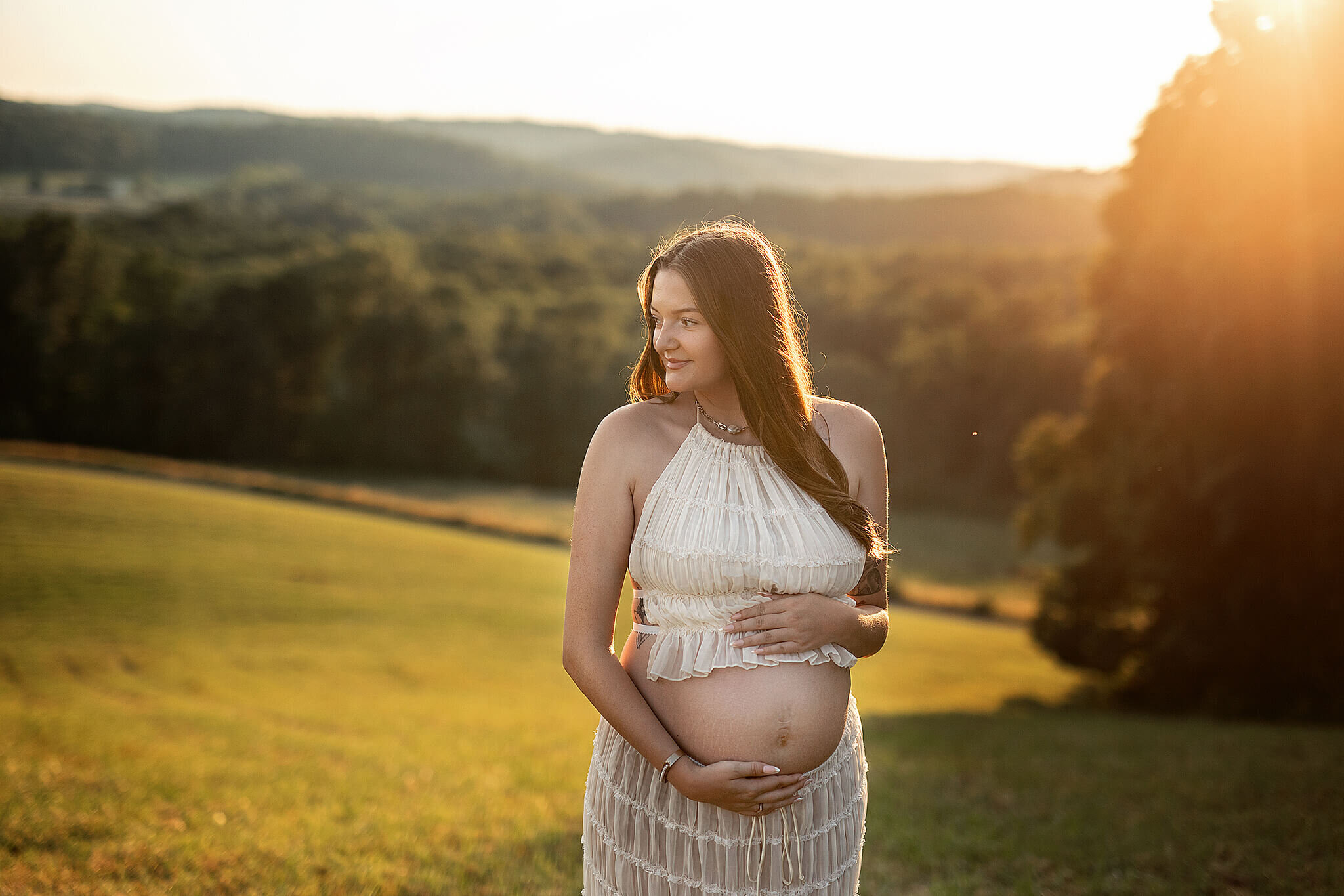 Maternity photo of mama standing on a hill