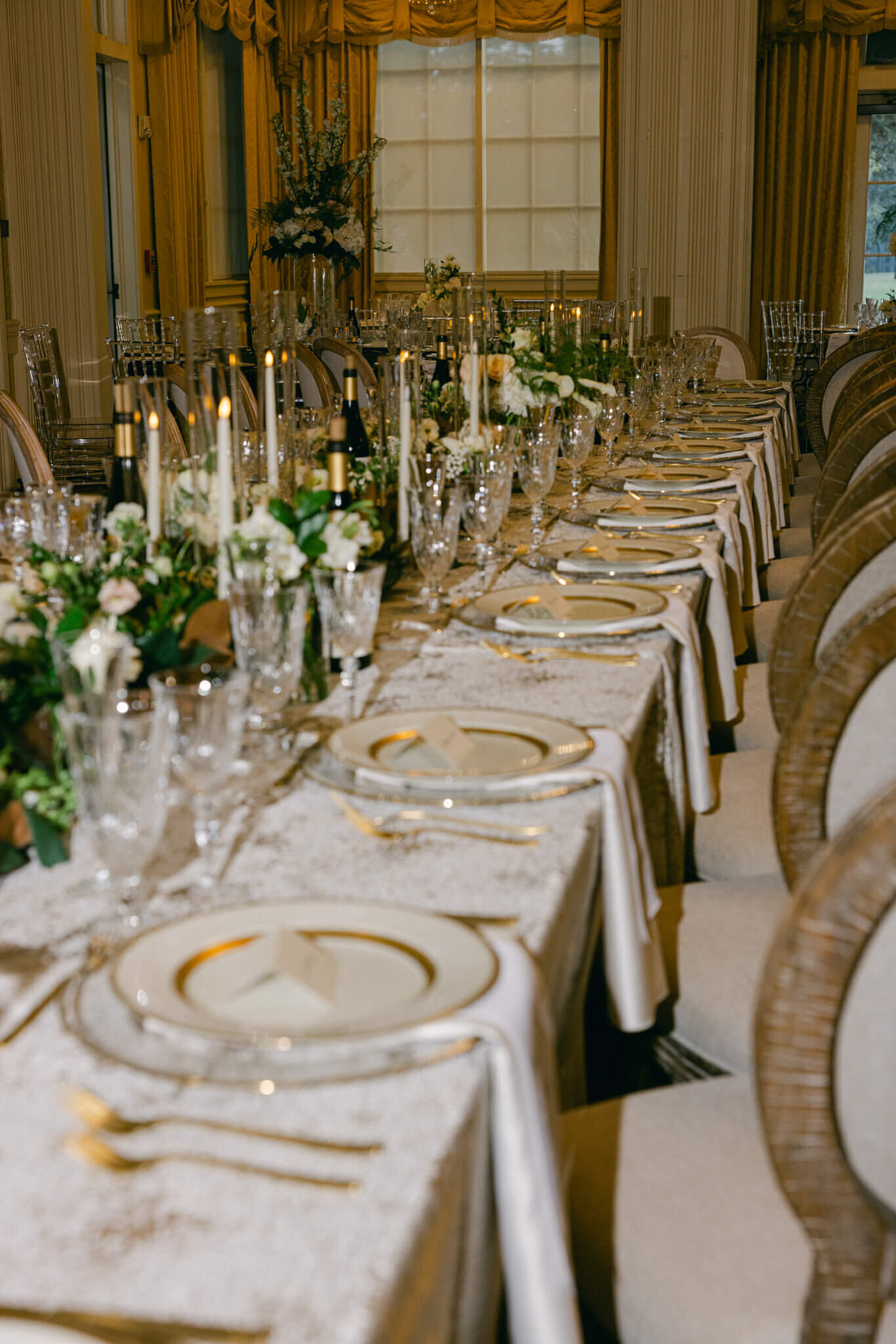 Photo of one of he reception tables at the wedding the table has fine linens, tableware, candles and wine on it