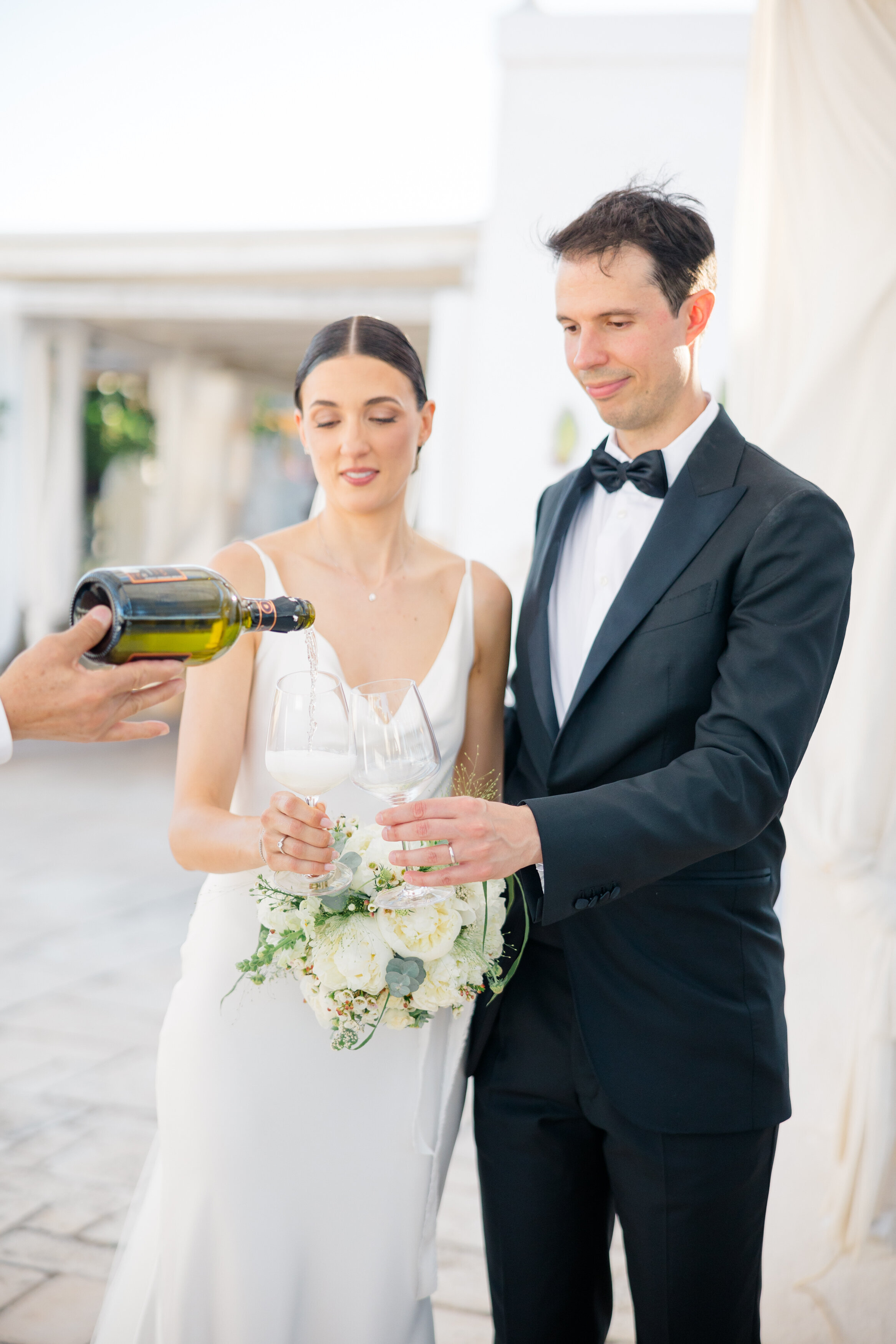 Wedding and Elopement Photographer, bride and groom getting pour their toasting champagne