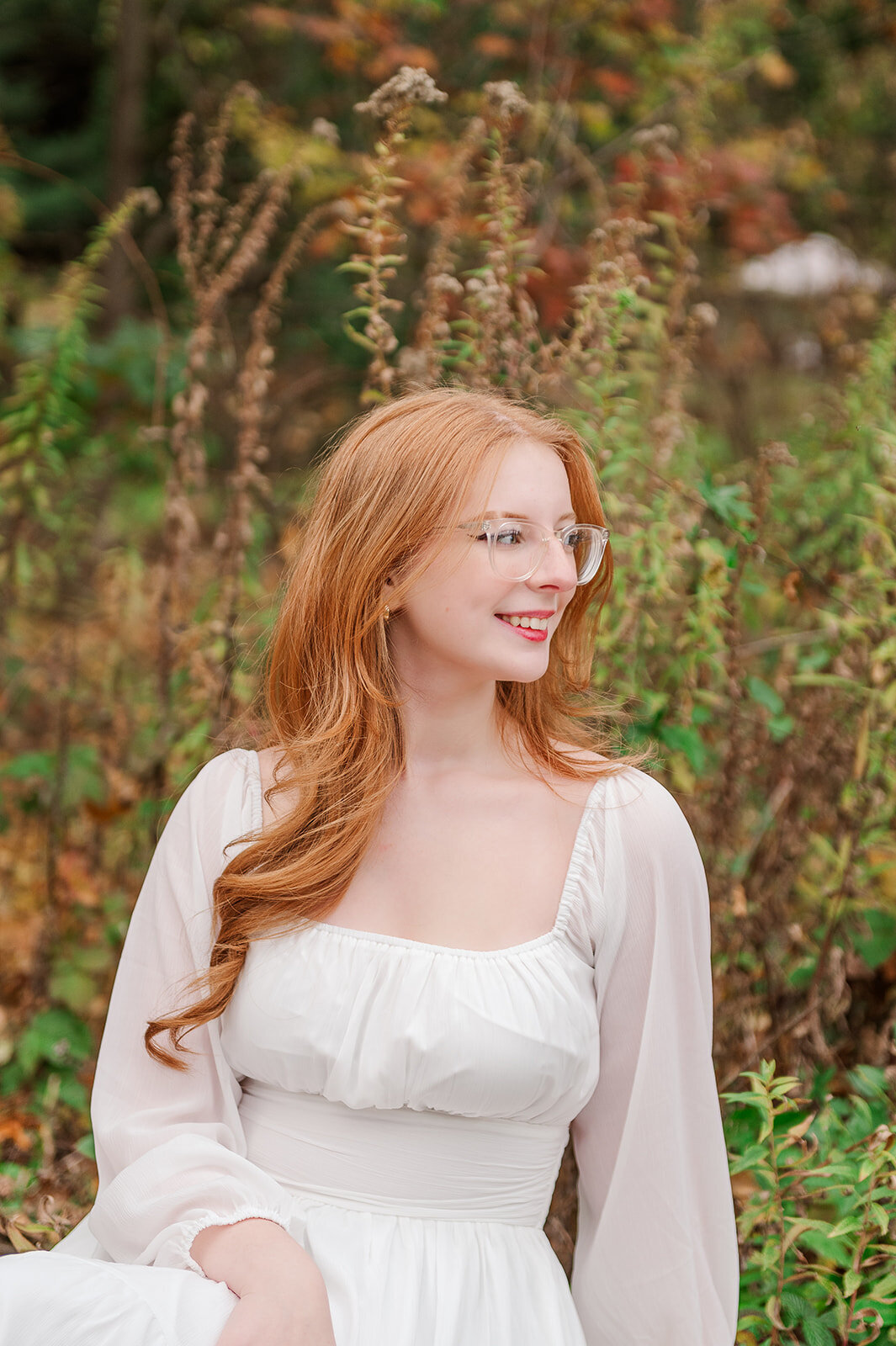 Senior girl with long red hair laughing during a golden hour fall session in York, PA