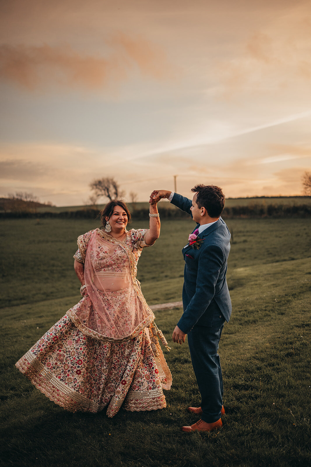 couple spin in field during sunset