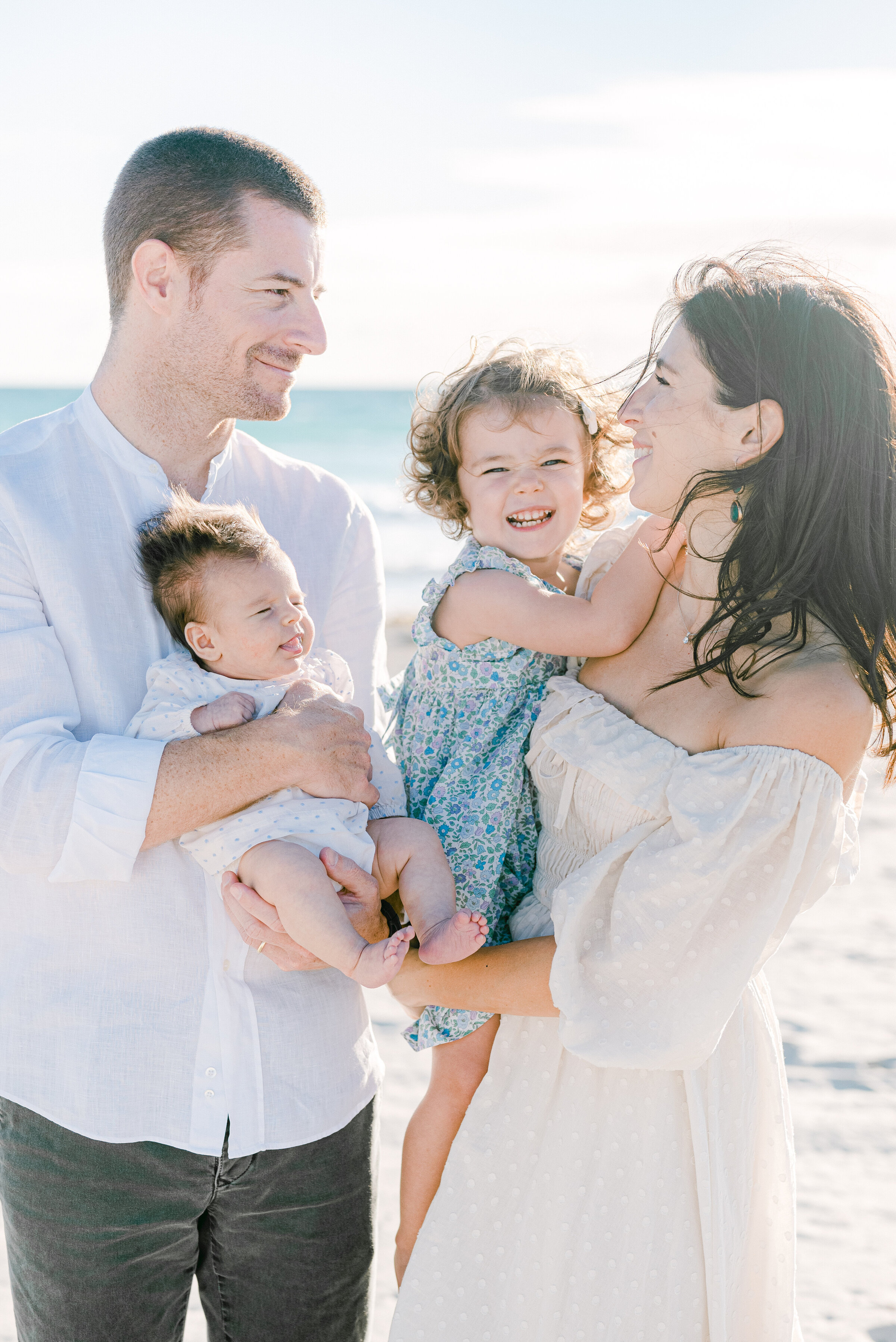 family of 4 hugging and laughing in south pointe park florida by Miami Family Photographer