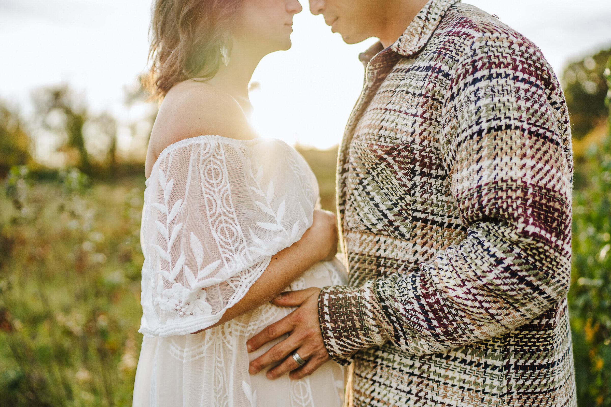sun shines between pregnant couple nose to nose during boston photoshoot