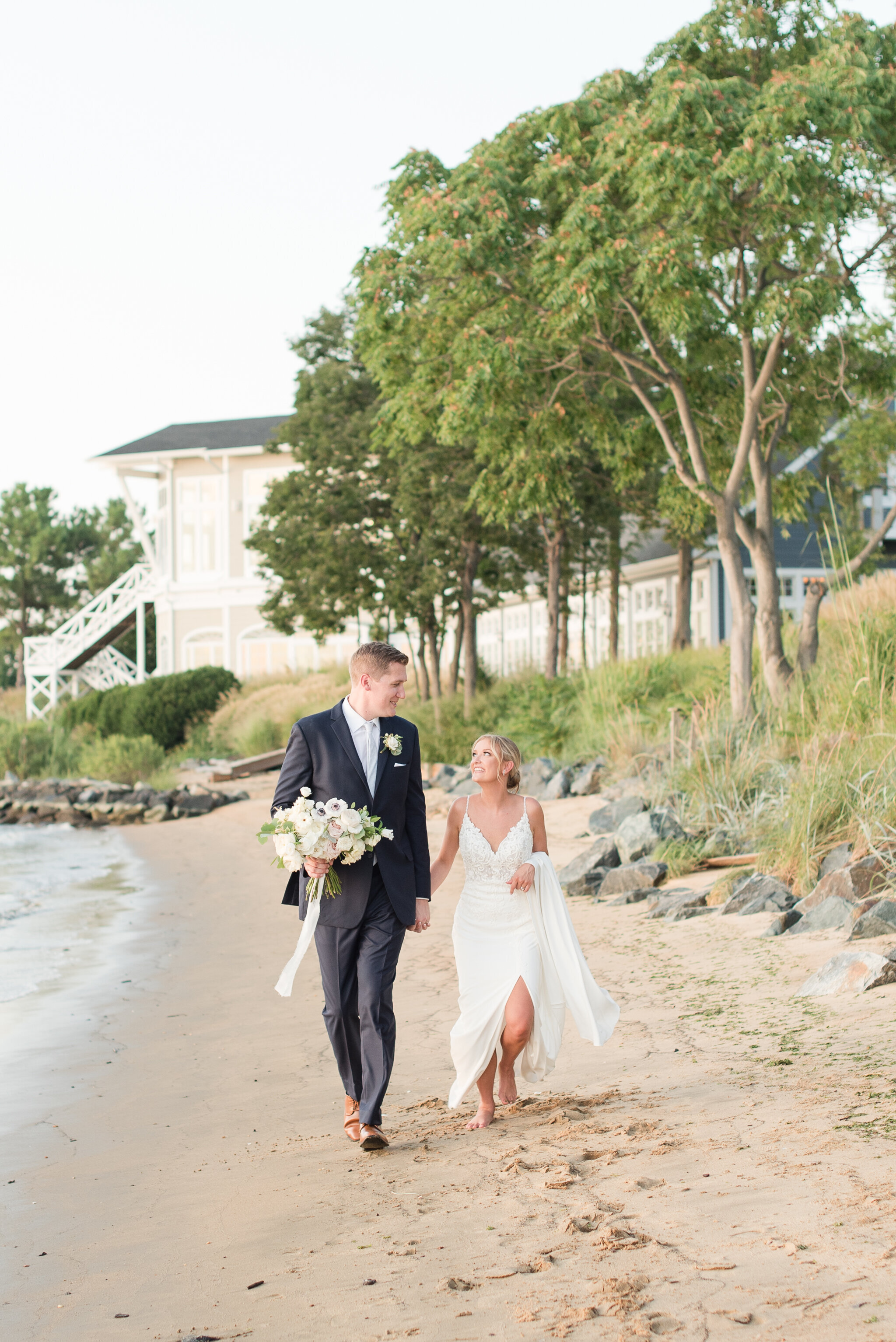 couple happily walking on the beach at sunset on wedding day