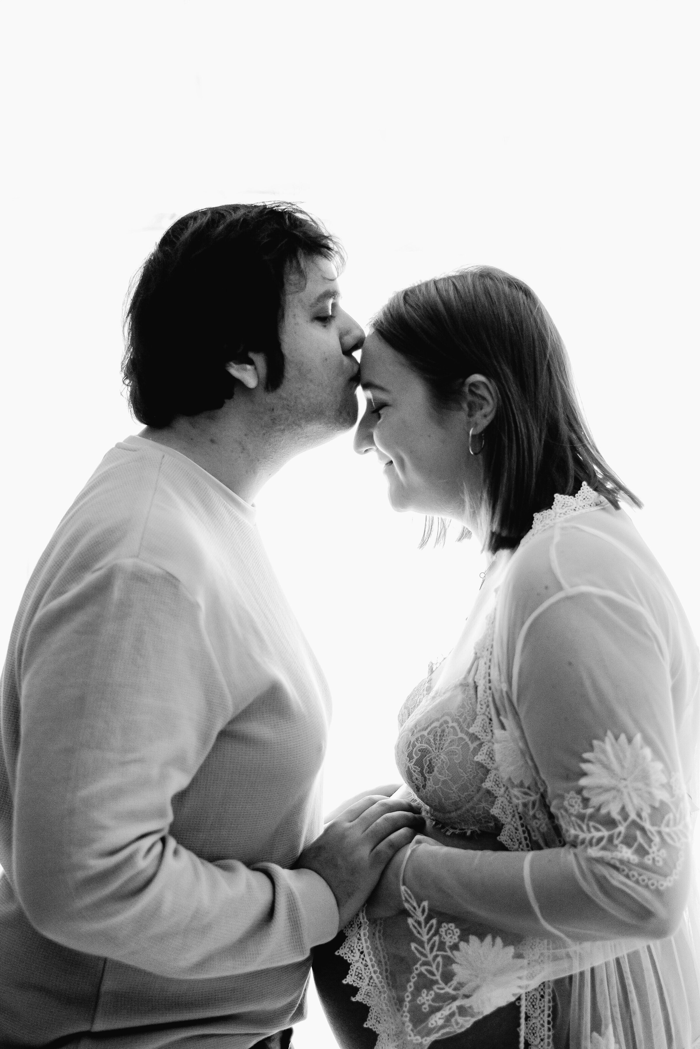 Father kissing pregnant mothers head at Billingshurst maternity photoshoot