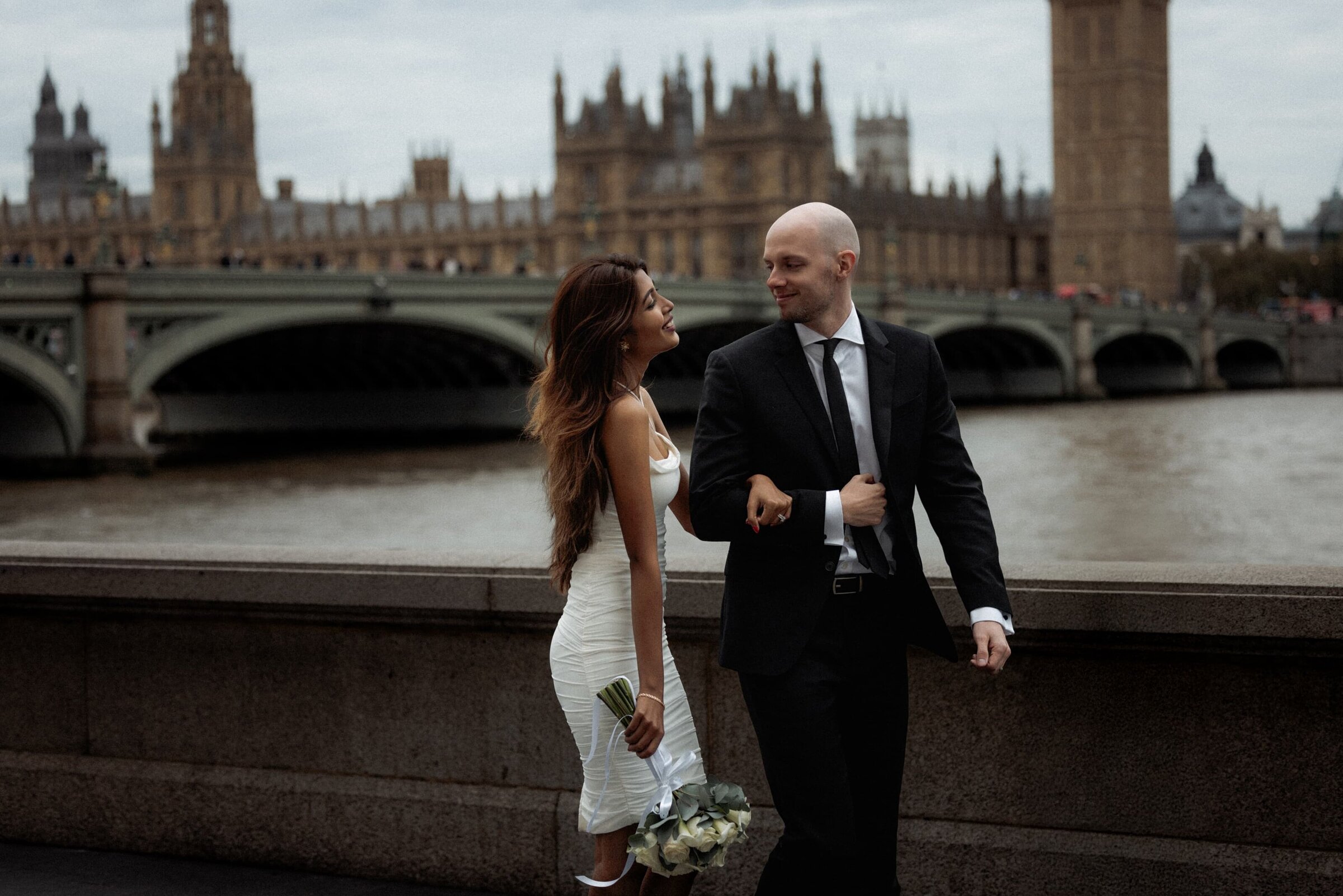 A bride and groom taking a stroll around London historical site of westminster and bigben after their small wedding in London
