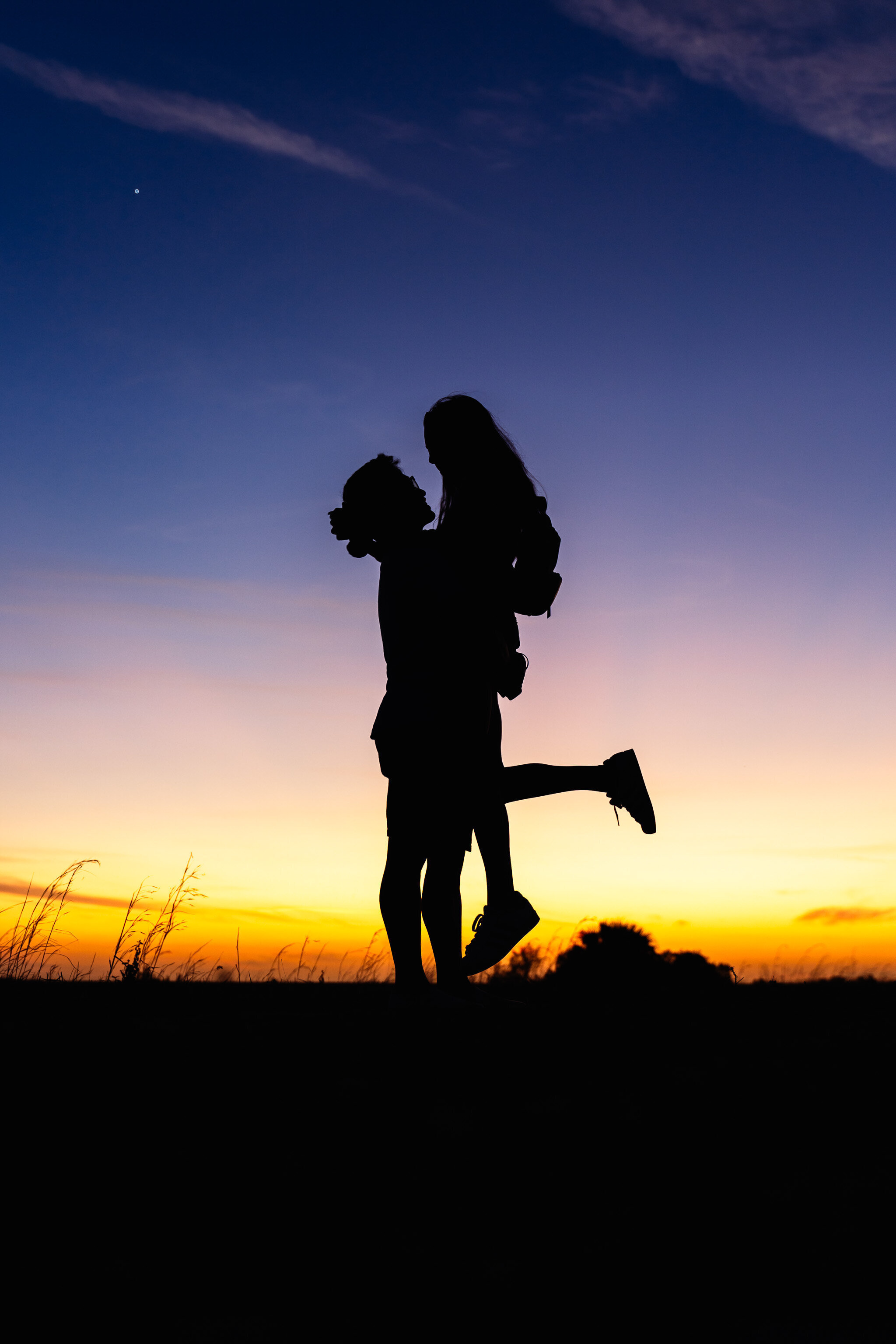 Silhouette of engaged couple with sunset backdrop