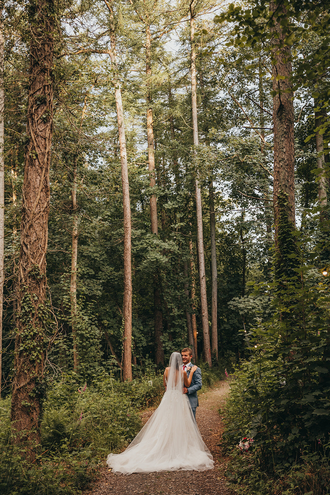newlywed couple embrace in the forest