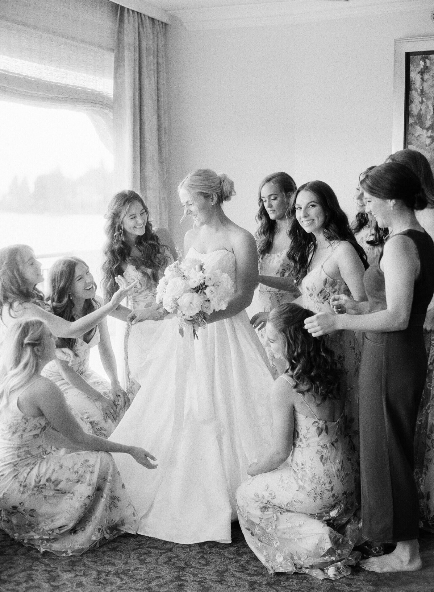 black and white film photo of bridesmaids helping bride get ready at the seattle tennis club