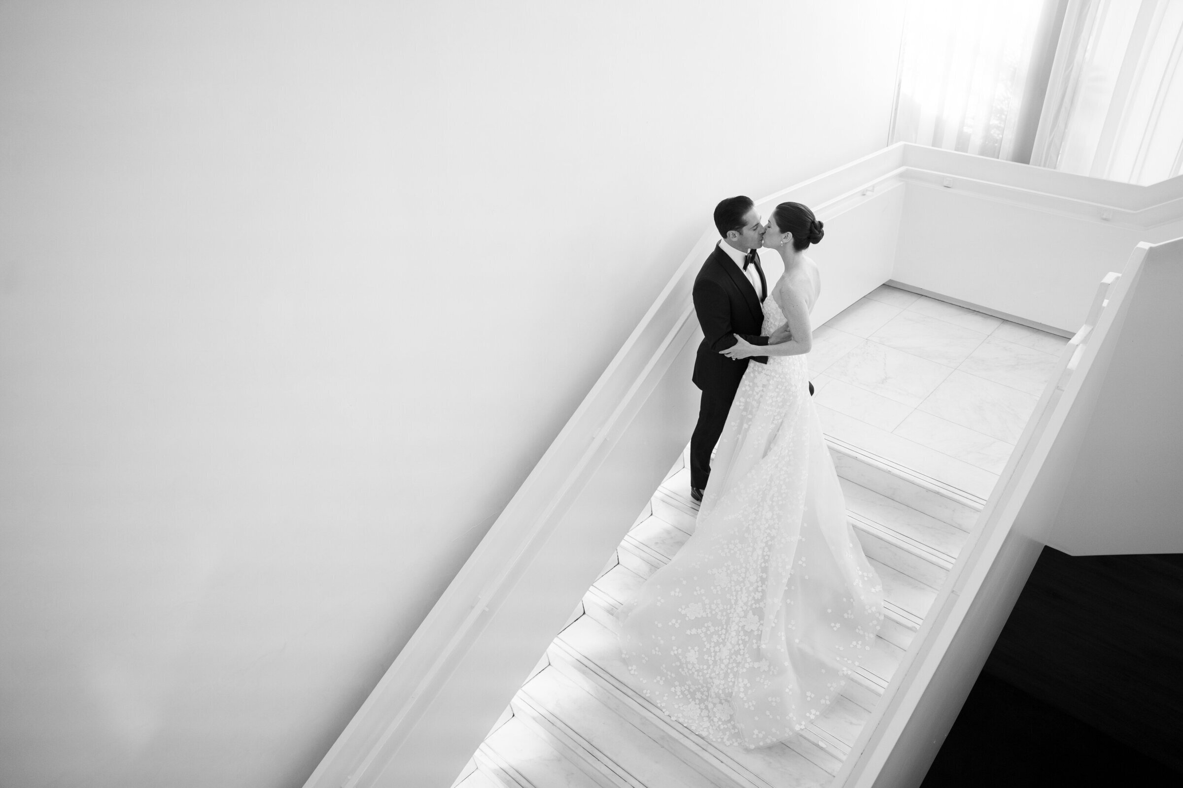 black and white photo of bride and groom kissing in stairwell captured by a miami wedding photographer