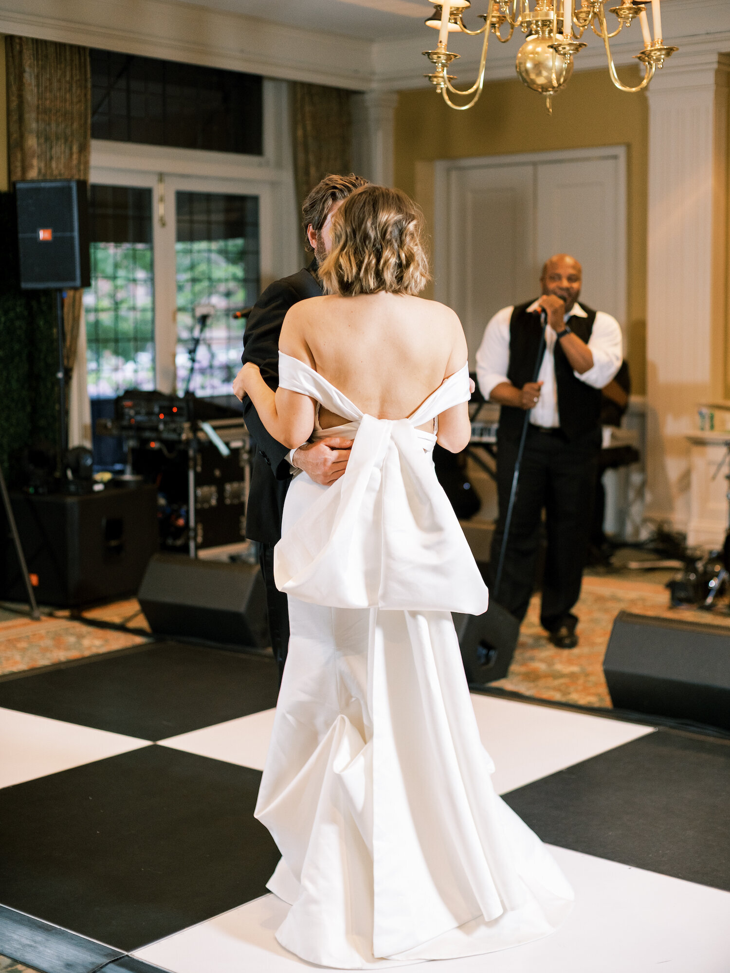 bride dances with groom on checkerboard dance floor
