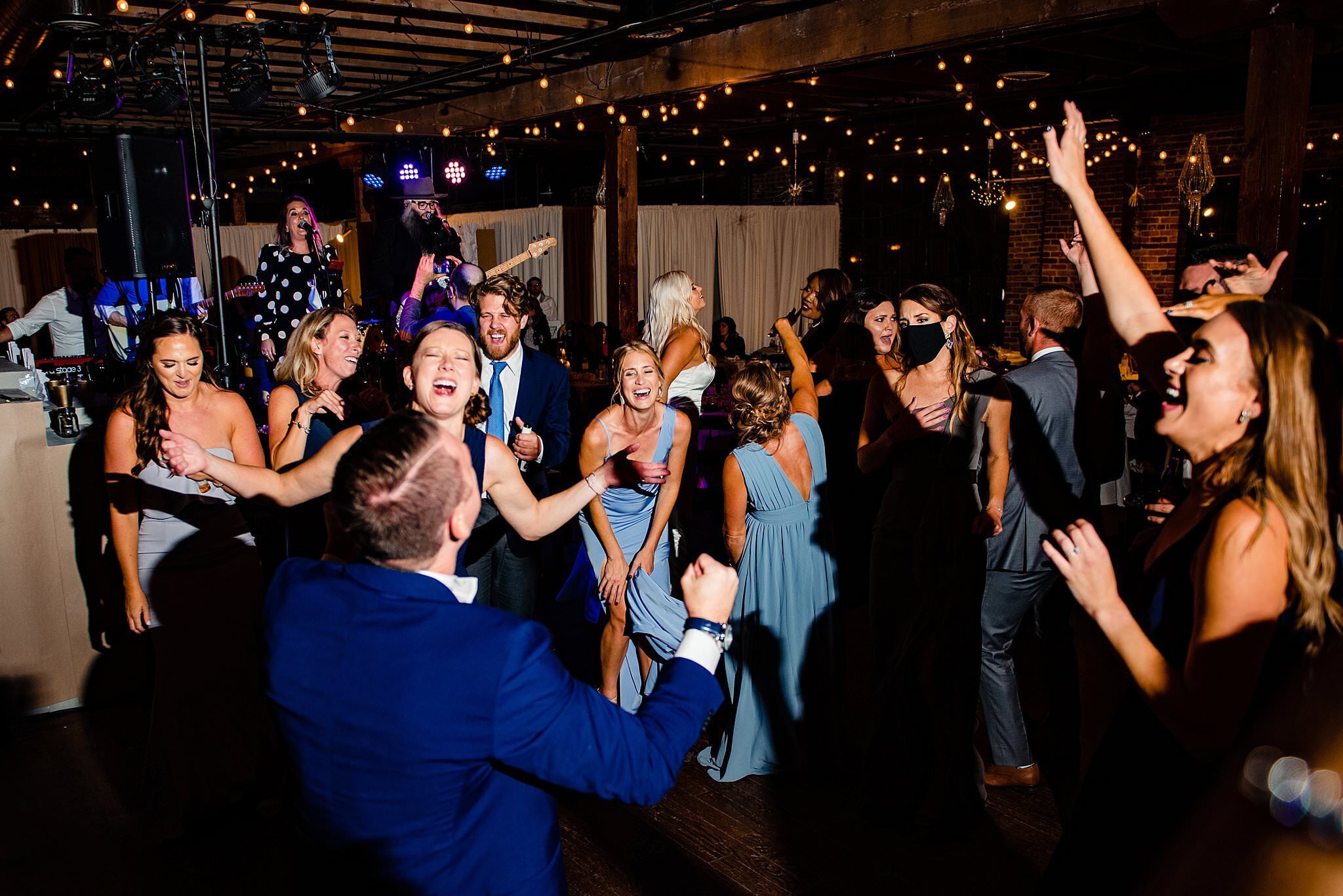 Guests on dance floor singing alongside the groom on the top floor of Marathon Music Works
