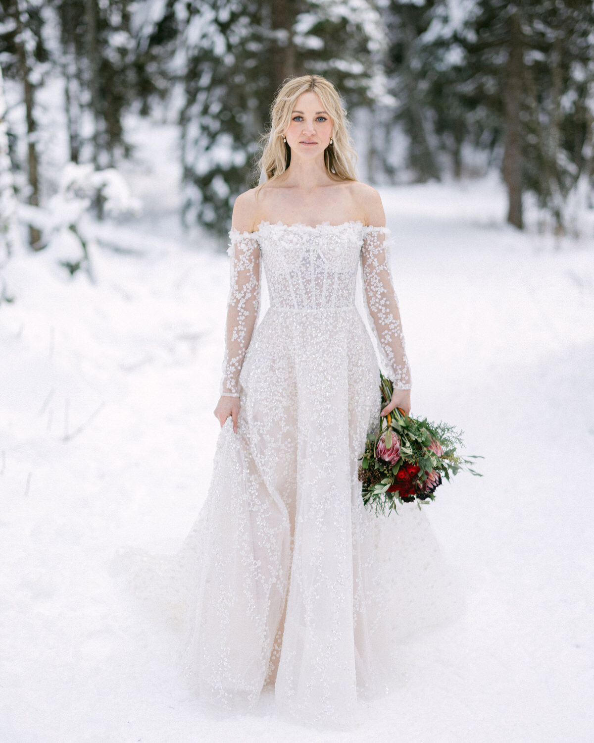 A stunning winter portrait of a bride walking gracefully through the snow at Chateau Lake Louise on her wedding day. Captured in the serene beauty of the Canadian Rockies, this timeless image showcases her elegance and quiet strength against the breathtaking snowy landscape.