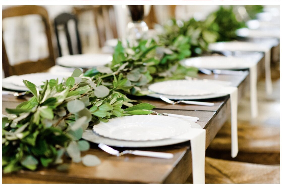 A gorgeous table scape with greenery down the center of the table