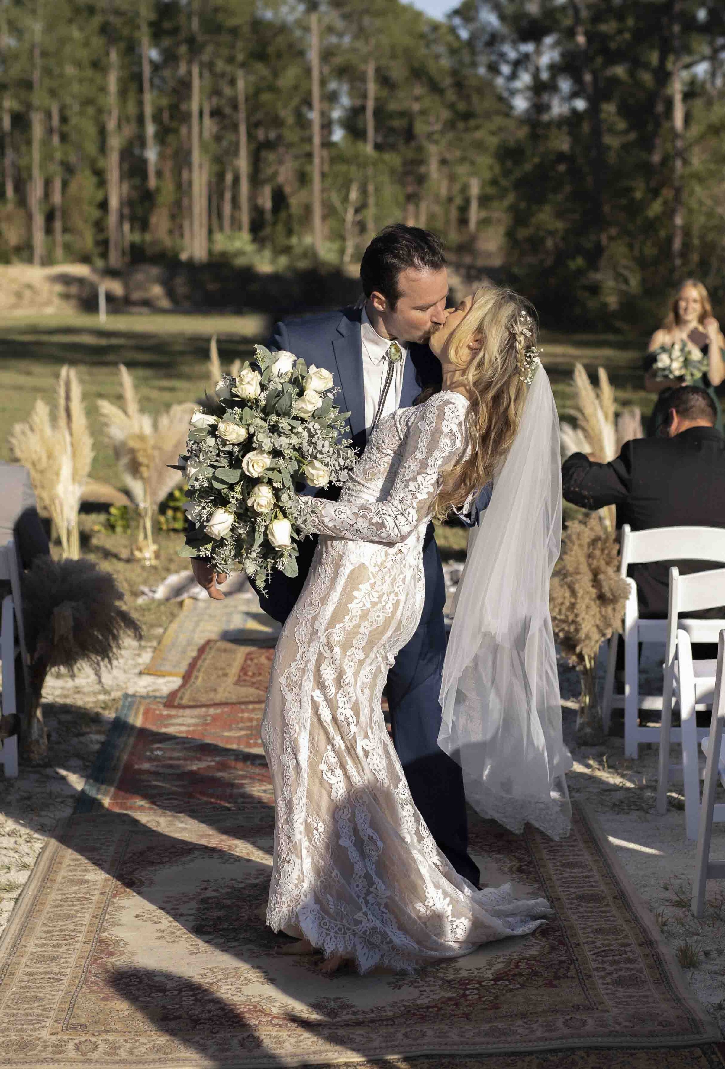 Bride and groom kissing at an outdoor wedding