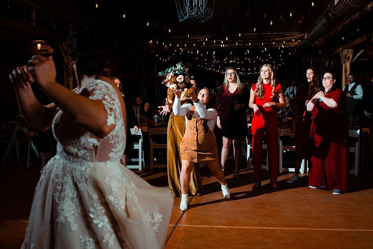 Guest jumping to catch bridal bouquet