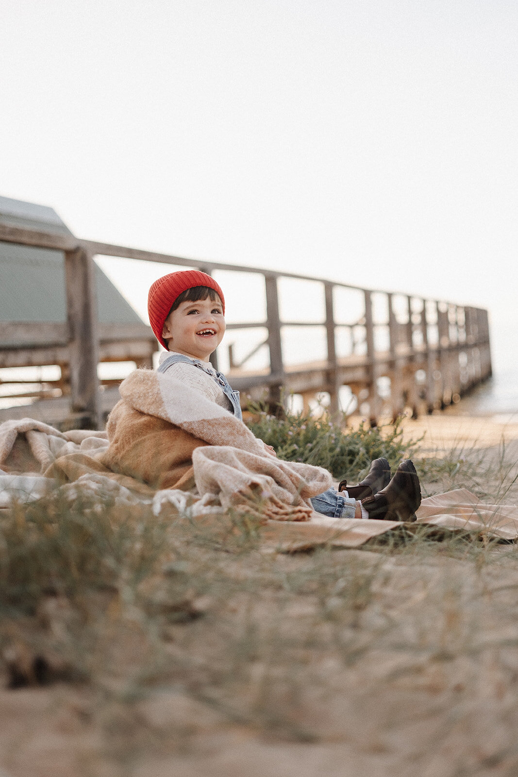 Beach family photographer Melbourne, boy sitting on beach