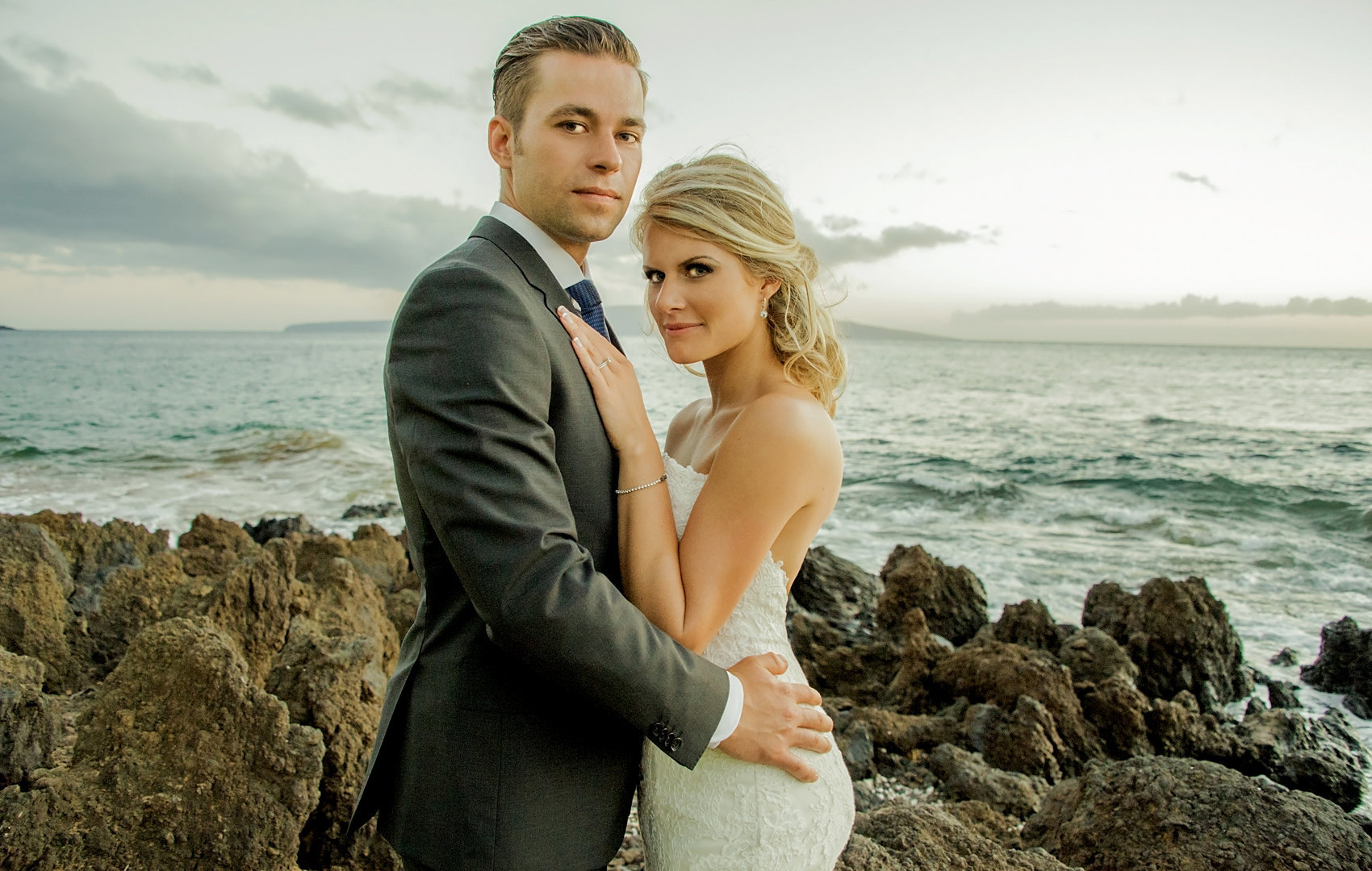 wedding couple  climbing the rocks for their photographer on Maui.