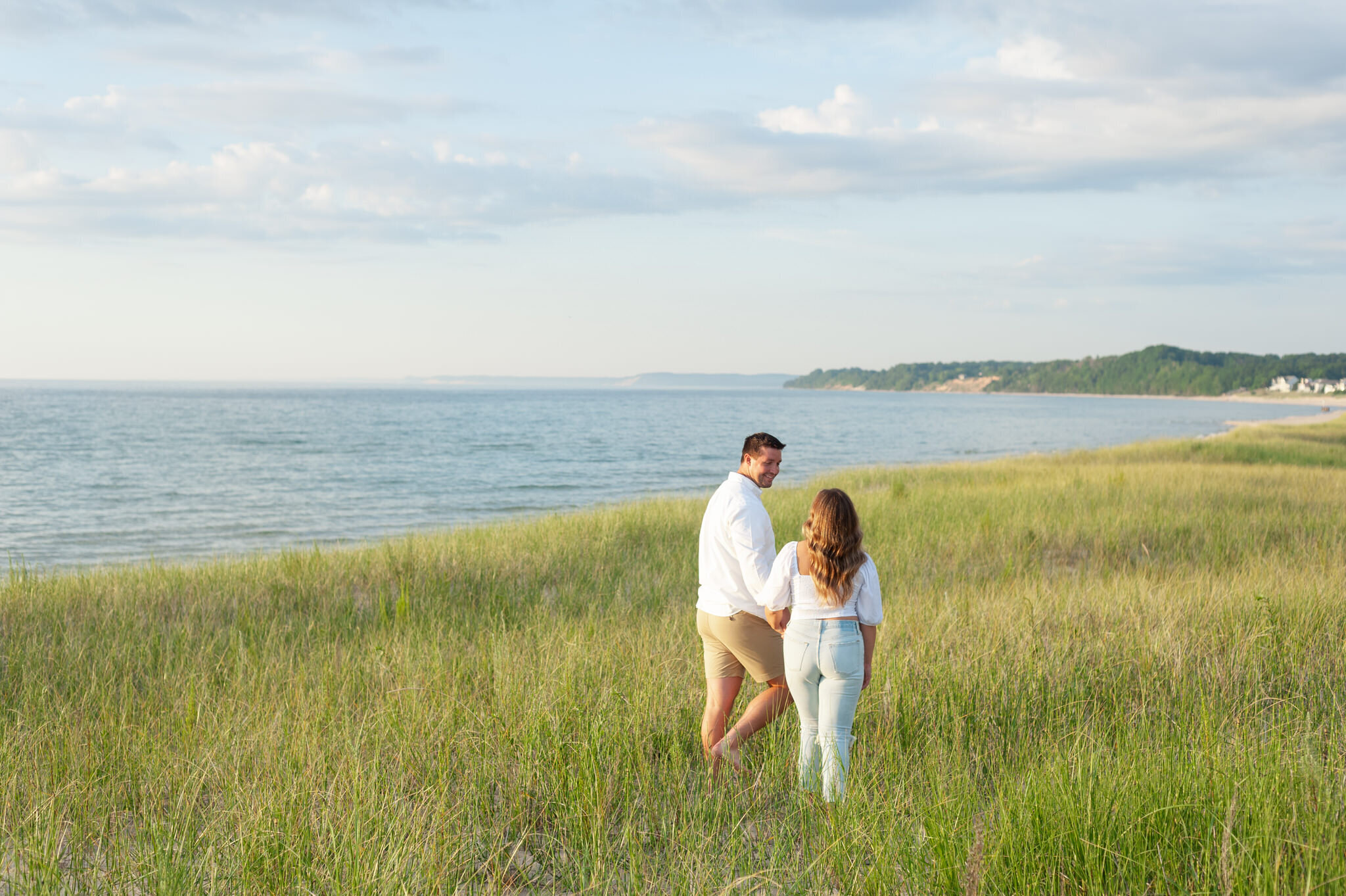 couple walking in beach grass in Manistee Michigan