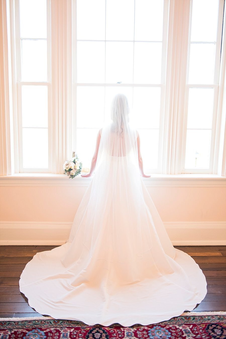 Bride looking out large windows at Ravenswood Mansion