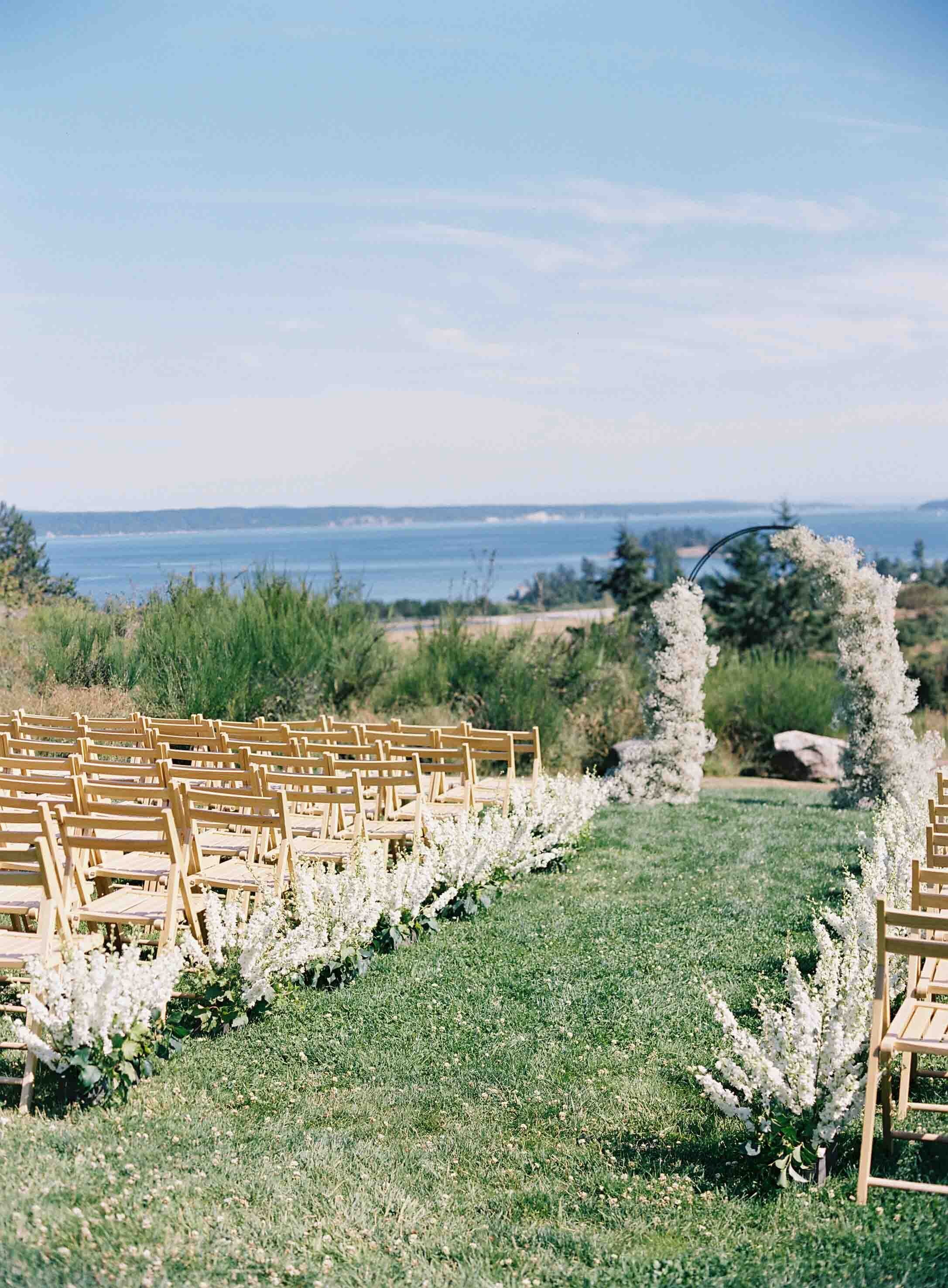 white babies breathe wedding ceremony decor aisle and arch overlooking water