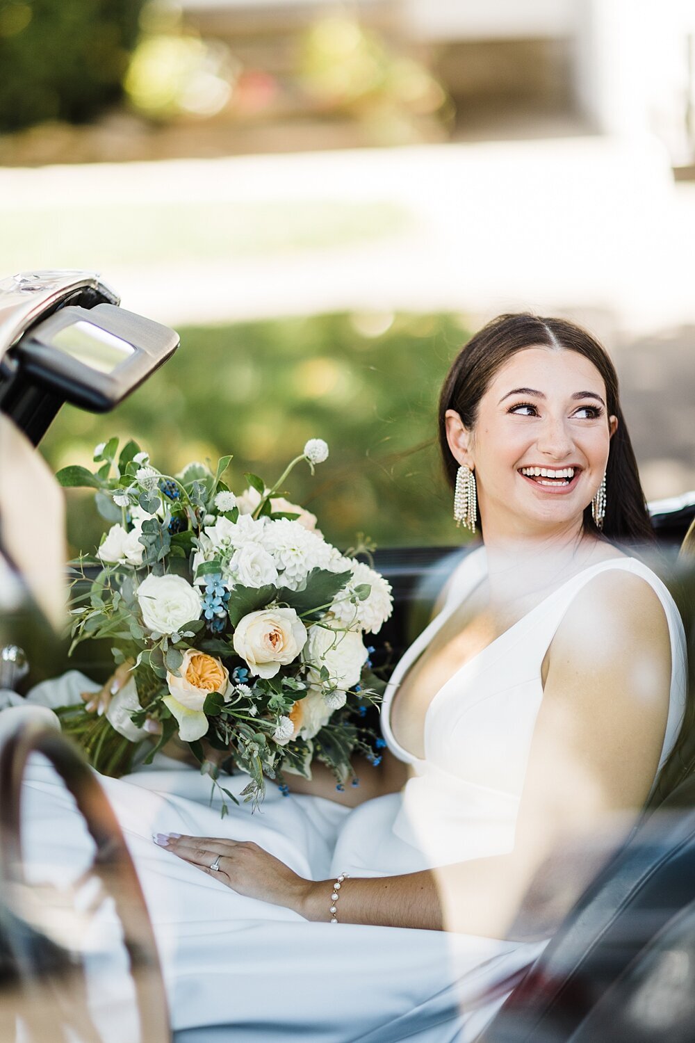 Bride looks over her shoulder in vintage Rolls Royce prior to wedding ceremony in Connecticut