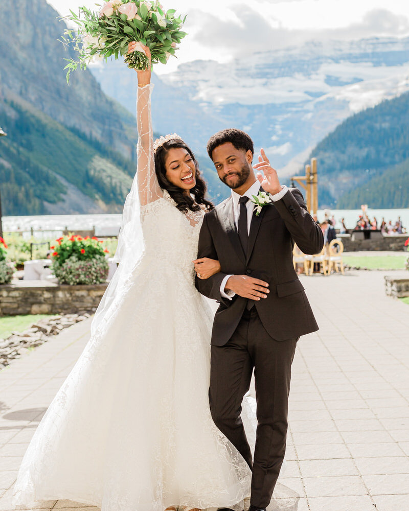 This beautiful moment captures the bride and groom walking down the aisle, filled with happiness and laughter after their ceremony at Chateau Lake Louise. With the stunning backdrop of Lake Louise behind them, the couple’s joy shines through, creating a perfect memory of their special day.