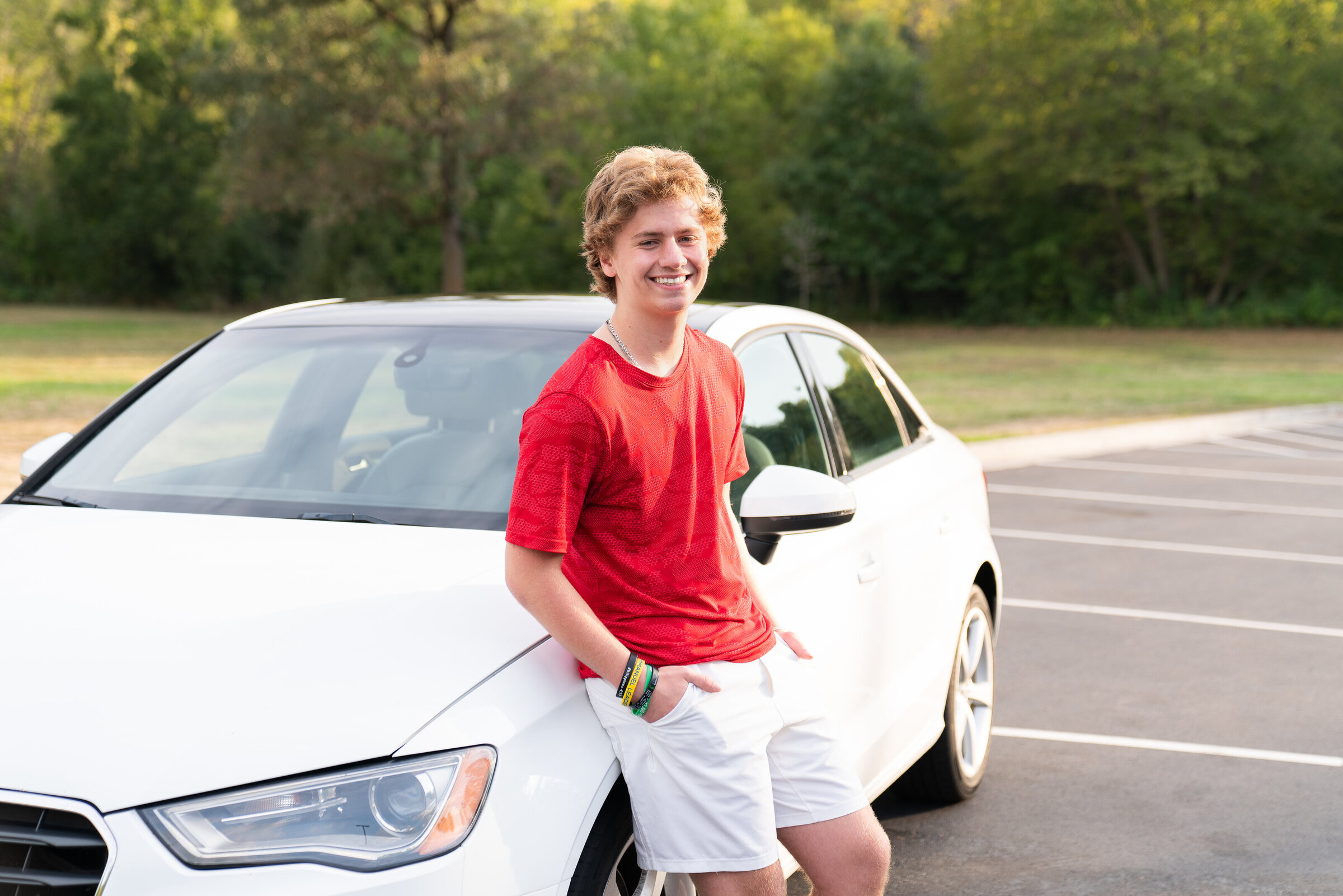 High school guy leans against his car for a senior picture