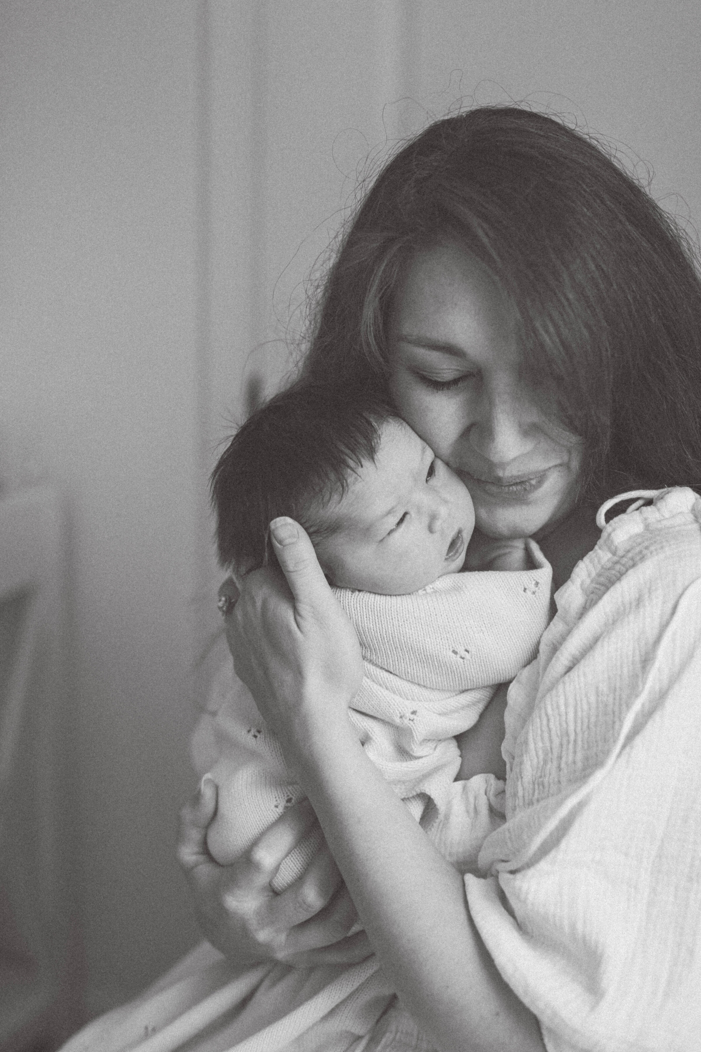 women holding newborn to her face smiling with eyes closed knoxville tennessee newborn photographer