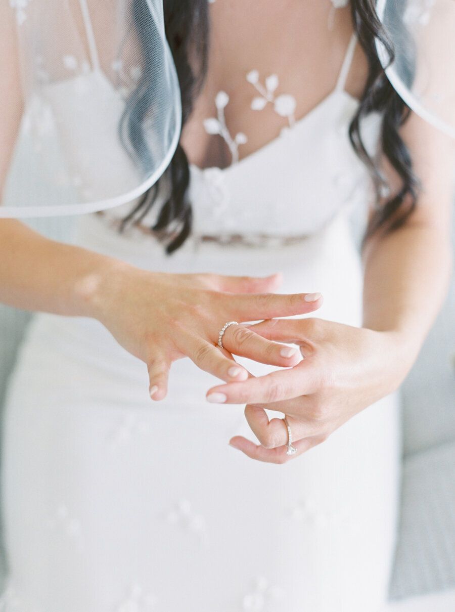 bride adjusts her wedding band on her finger