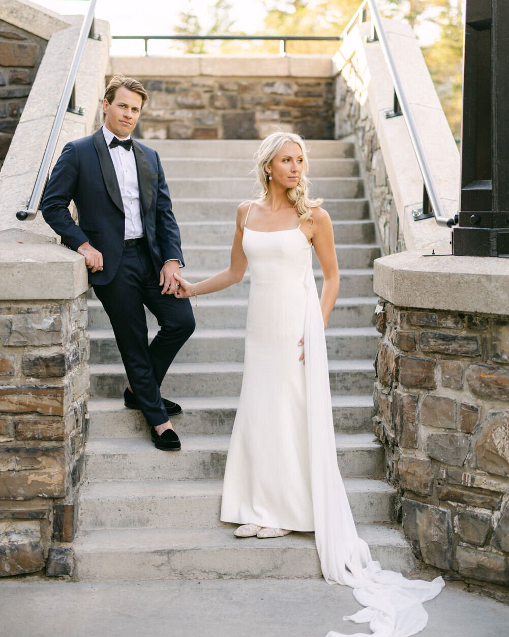 This stunning portrait captures the bride and groom on the iconic steps of the Banff Springs Hotel at sunset. Bathed in the golden light, the couple radiates elegance and romance, framed by the grandeur of the historic hotel's architecture.