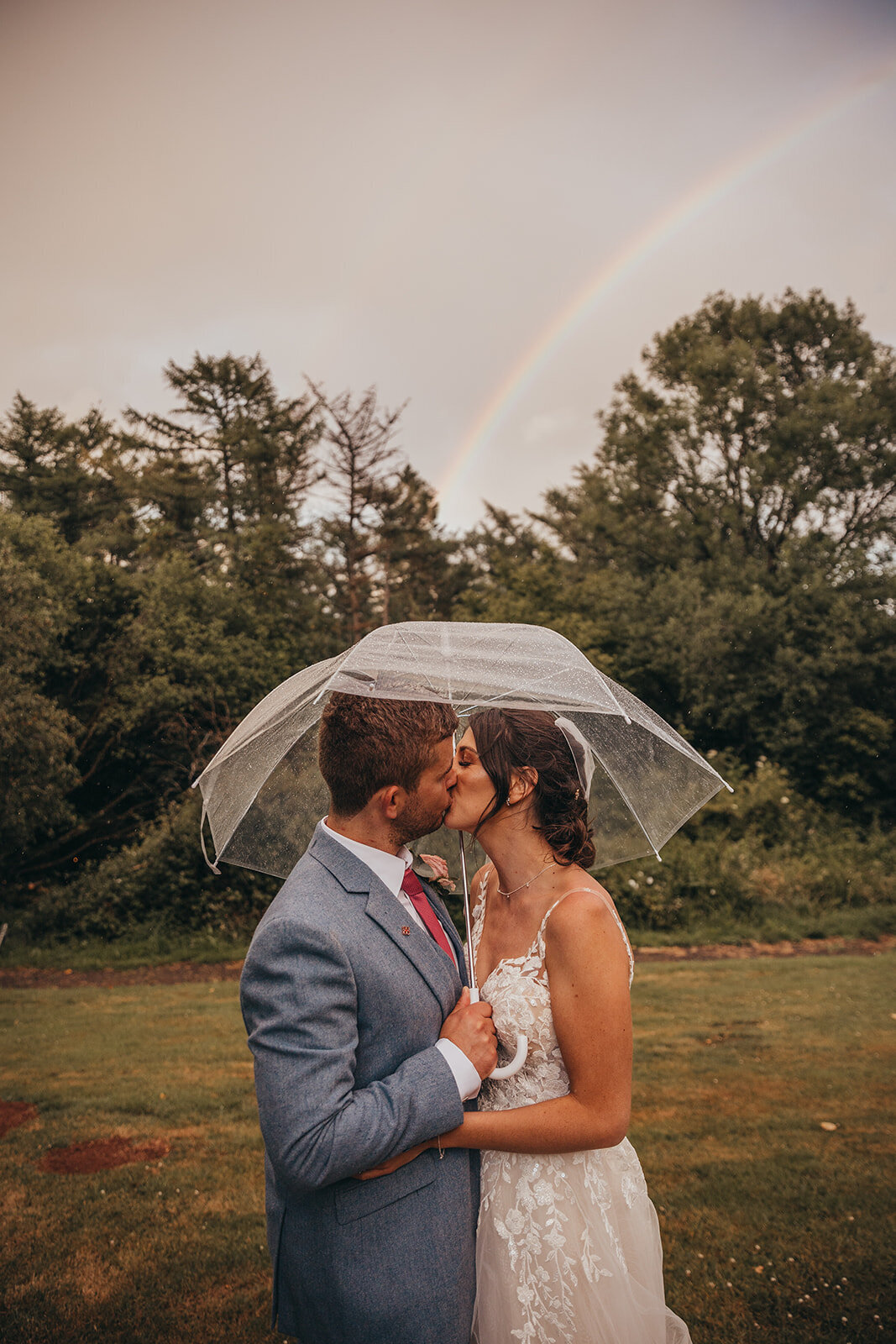 couple kiss under an umbrella in the rain