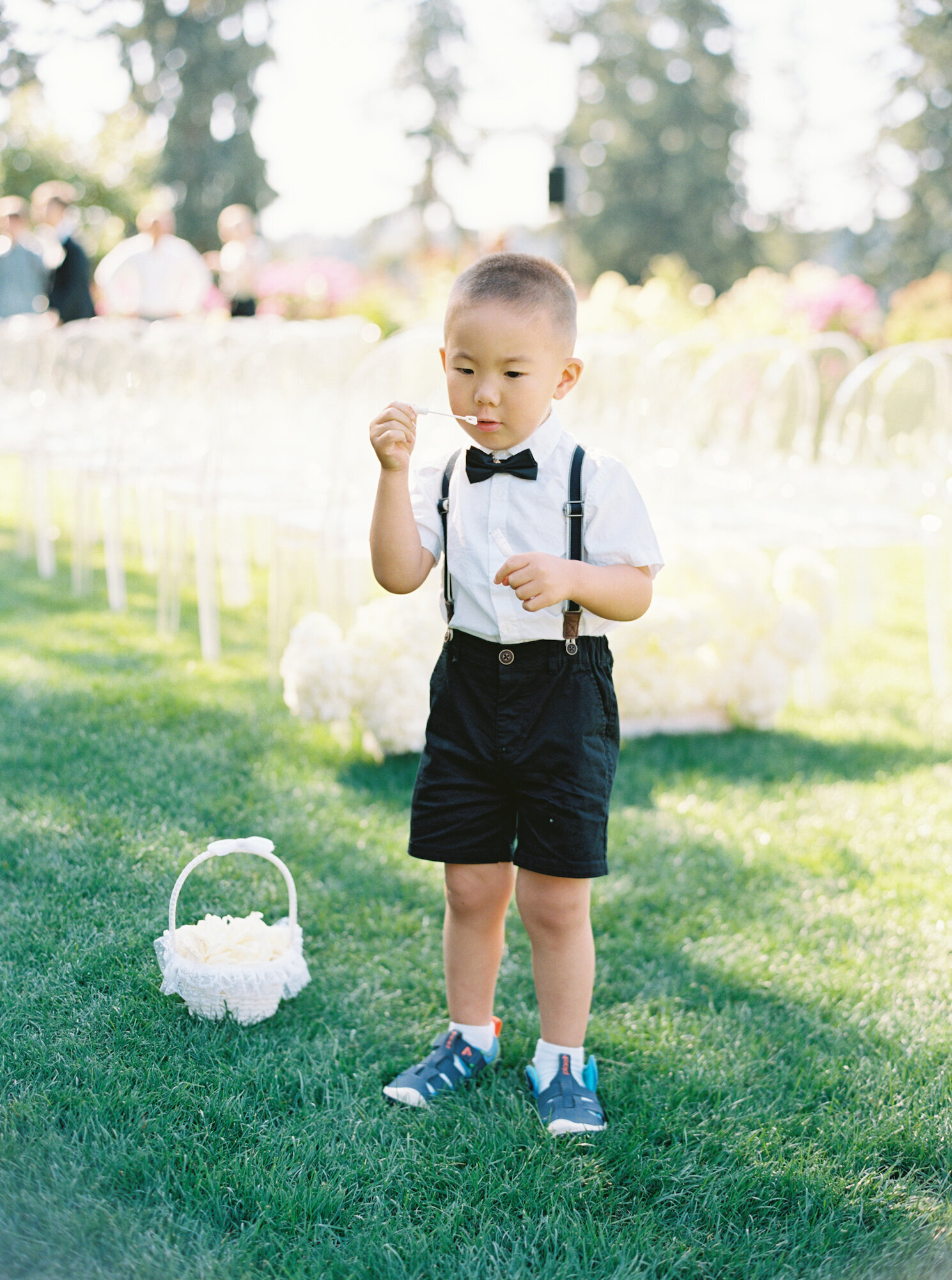 adorable ring bearer boy blowing bubbles at wedding