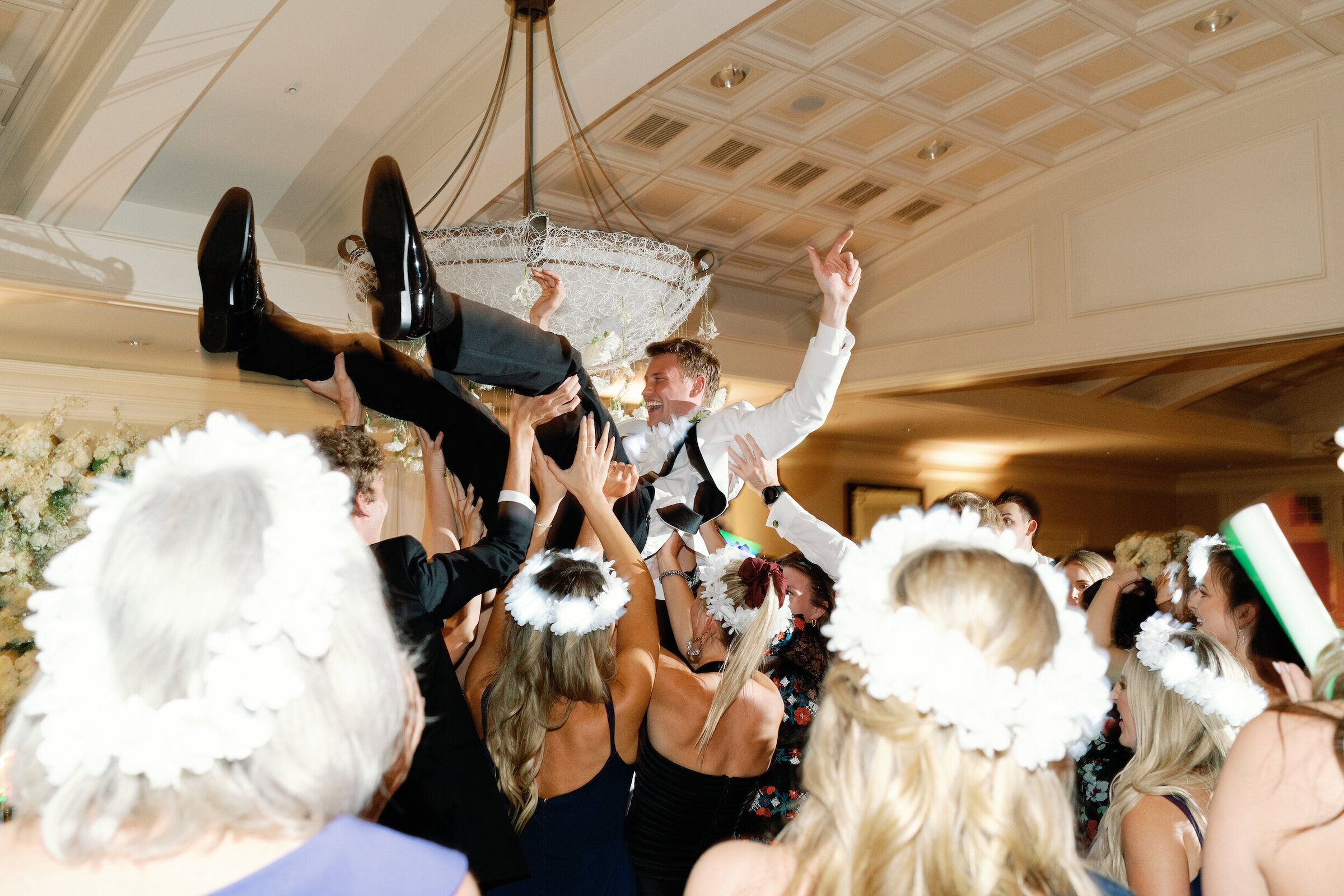 groom in white tux dancing at wedding reception