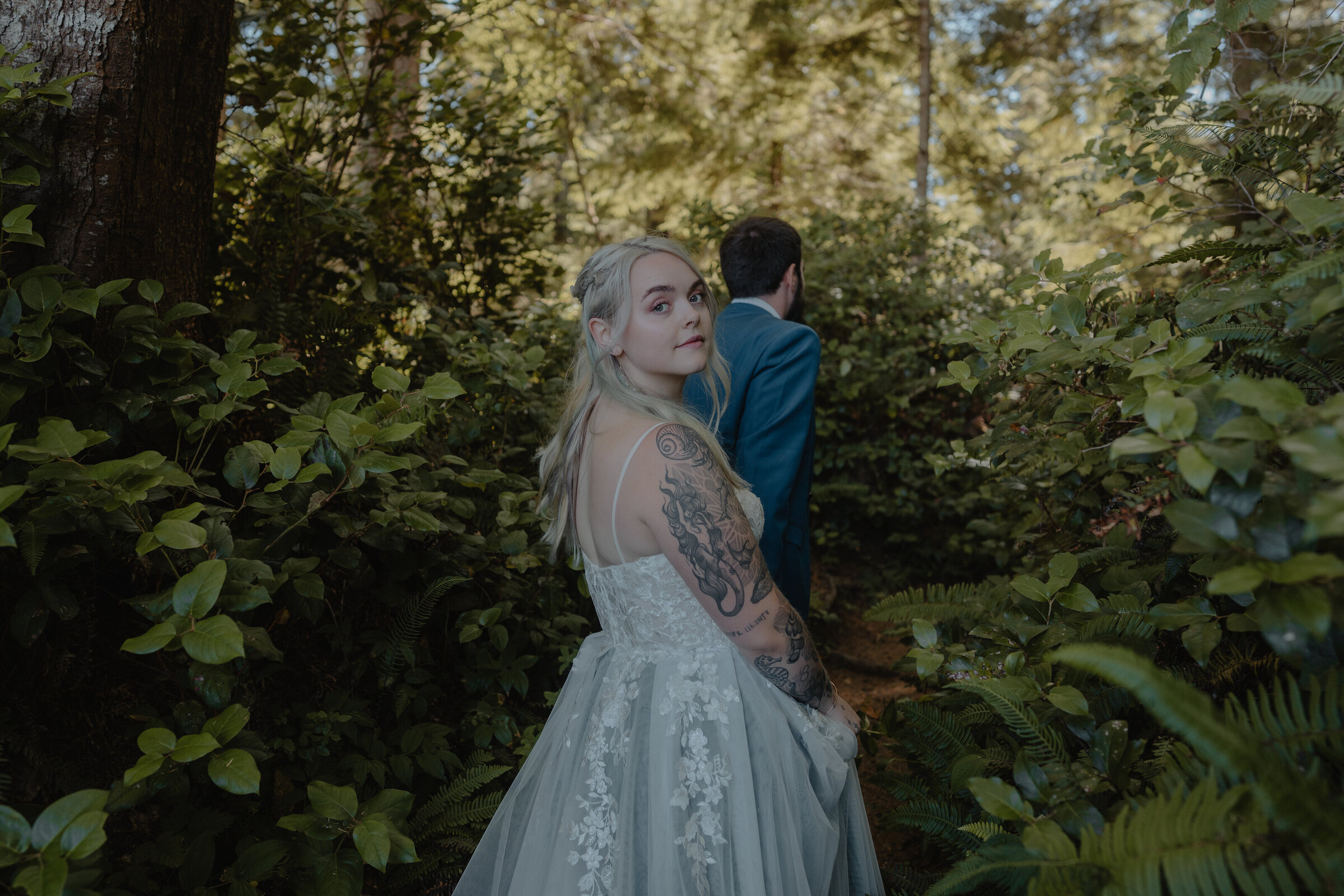 Playful newlyweds running along the shore in a candid Los Angeles forest wedding photo