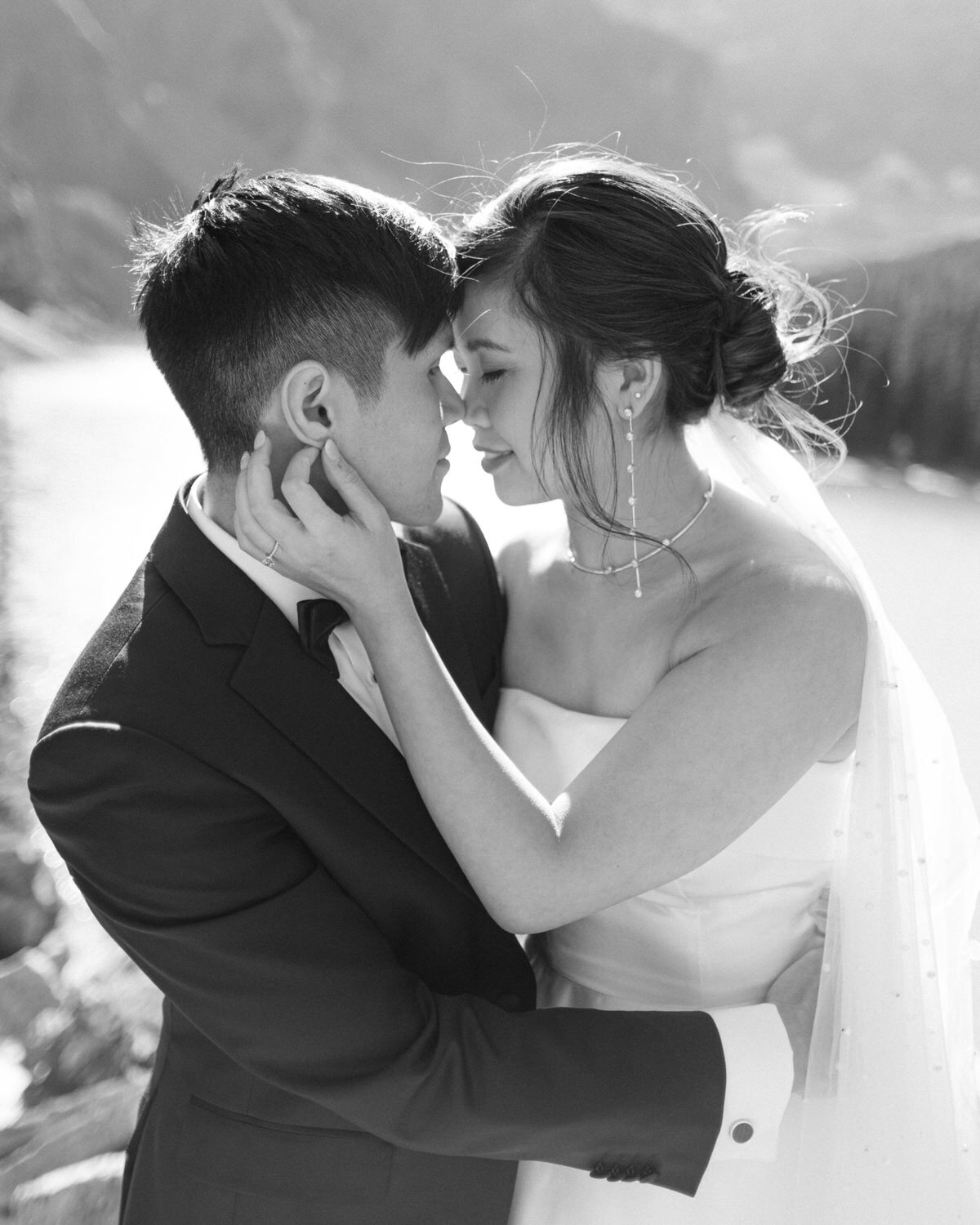 This beautiful image captures the bride and groom holding each other at Moraine Lake on their wedding day. The clear, sunny skies and stunning turquoise waters provide the perfect backdrop for this romantic and joyful moment.