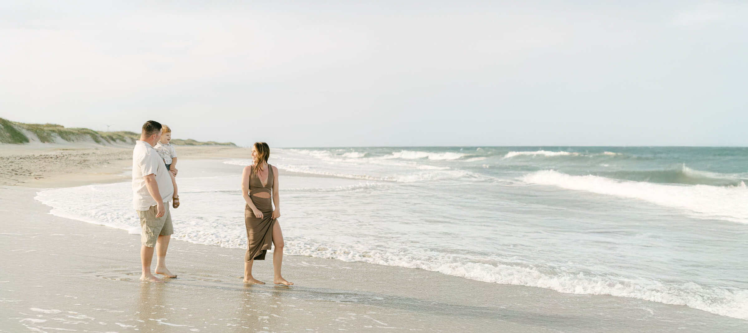 Family holding hands walking on the beach of the Outer Banks