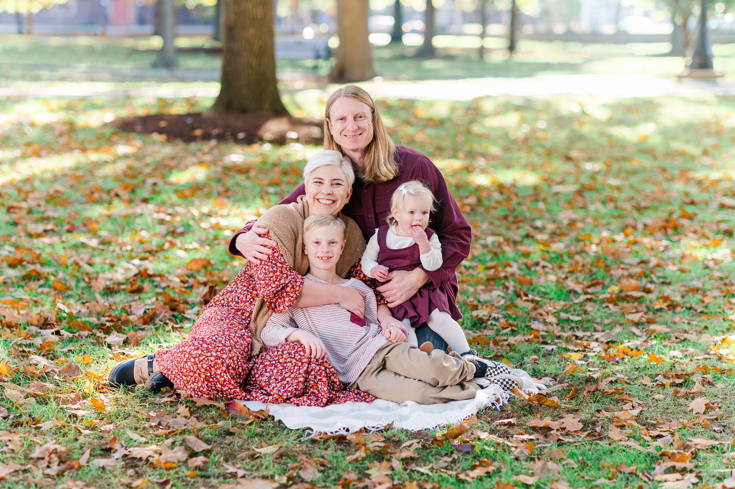 family of four sitting on a blanket on a college campus in fall york pa