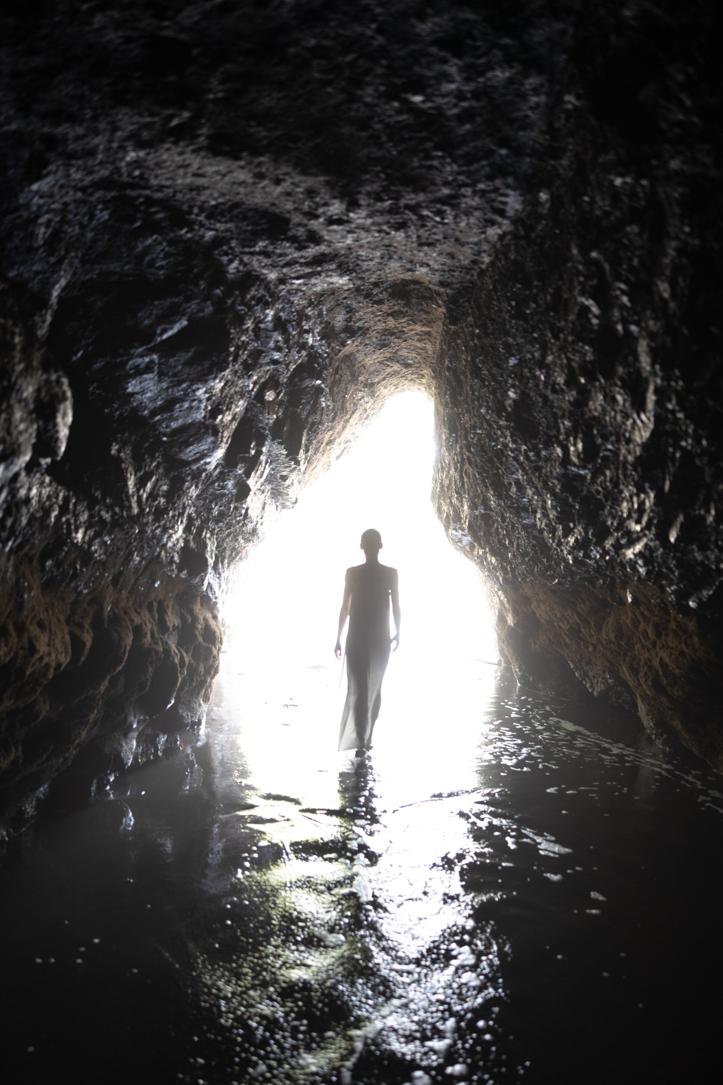 a silhouette of a woman in a cave