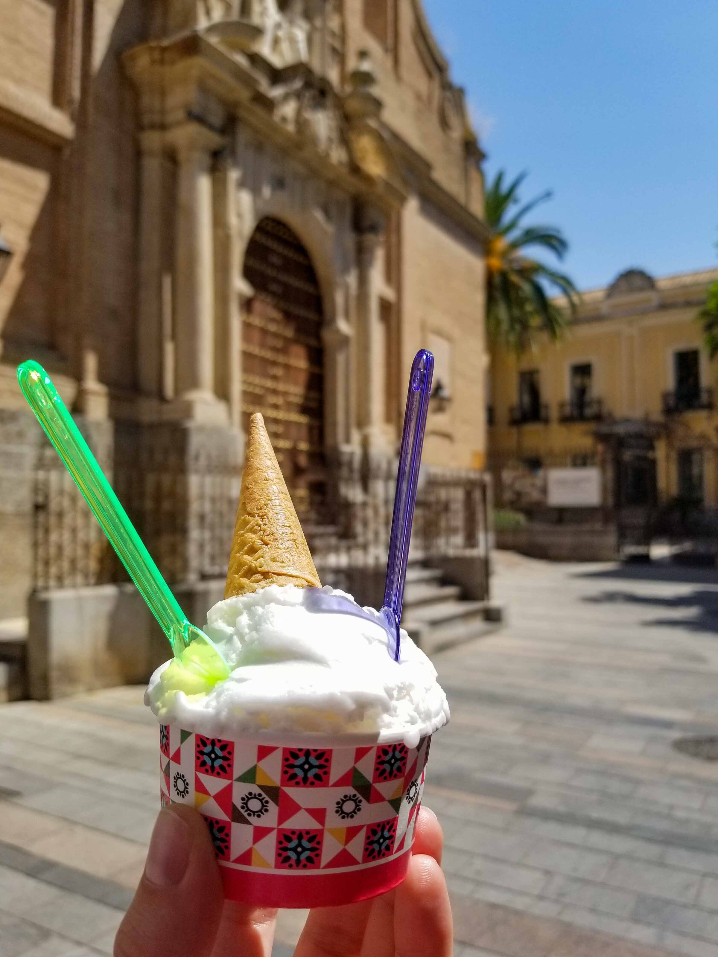 A hand holding a cup of ice cream in front of a church on a hot summer day in Cordoba, Andalusia, Spain ©Stephanie Dosch | theViatrix Luxury Travel