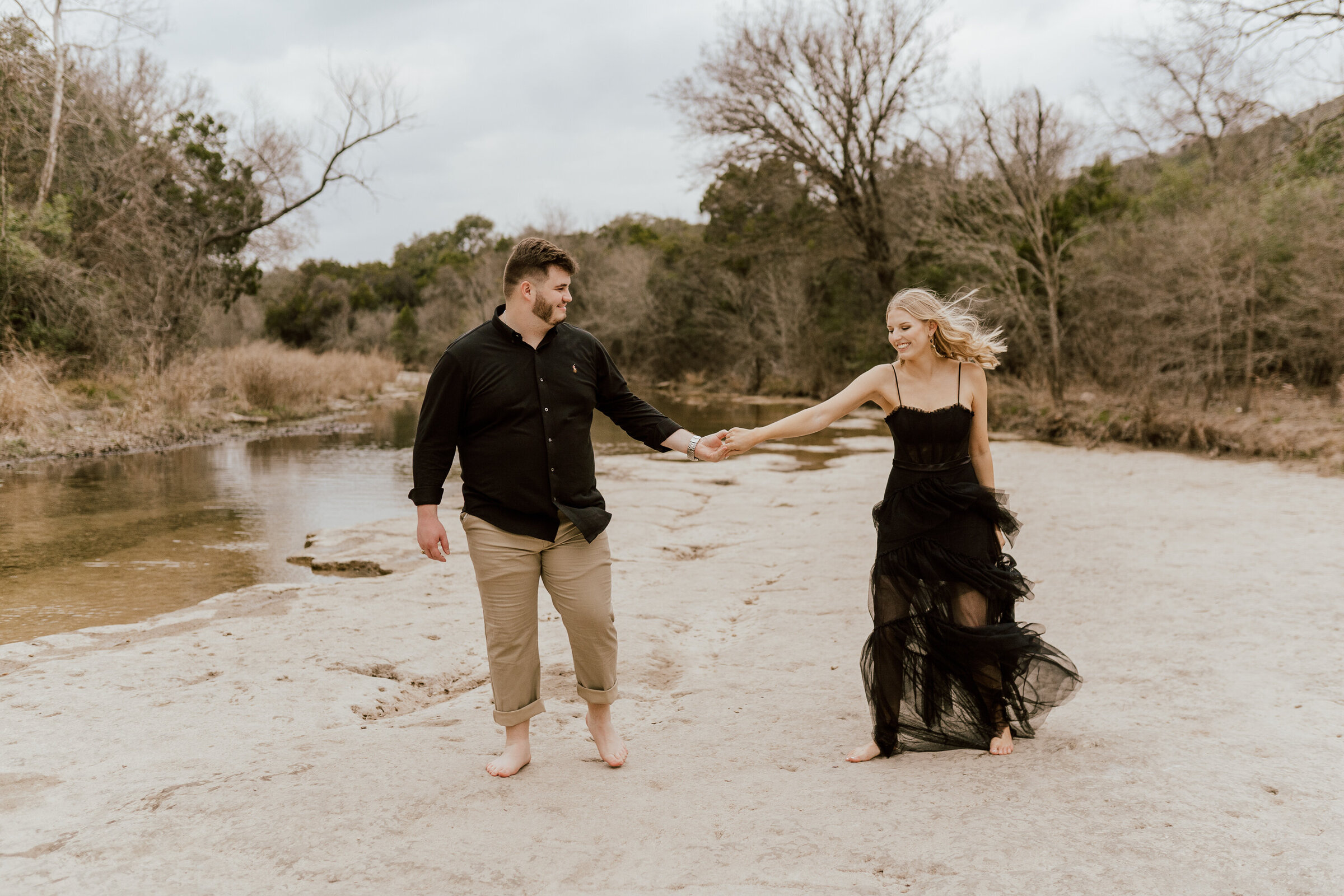 Austin Texas wedding photographer. Engagement photos. Black dress. ATX nature location. Bull Creek Park. Winter engagement photos. Warm  edits.