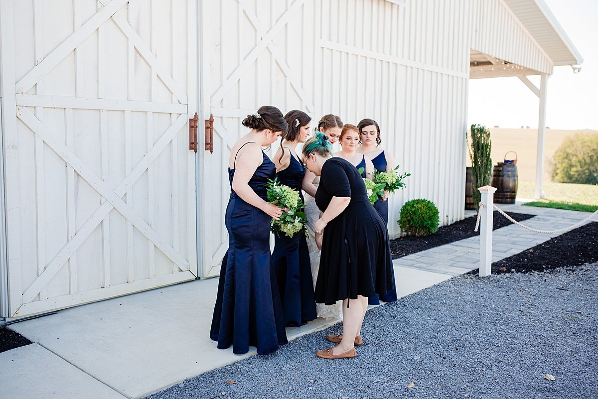 Mahlia helping the bridesmaids outside of the White Dove Barn during photos