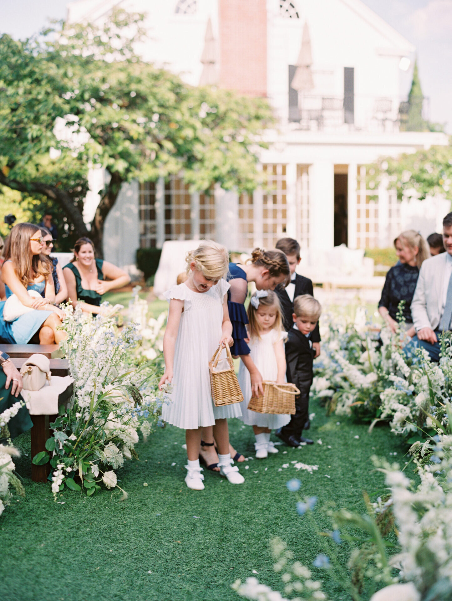 children walking down the aisle at wedding ceremony on green grass in seattle